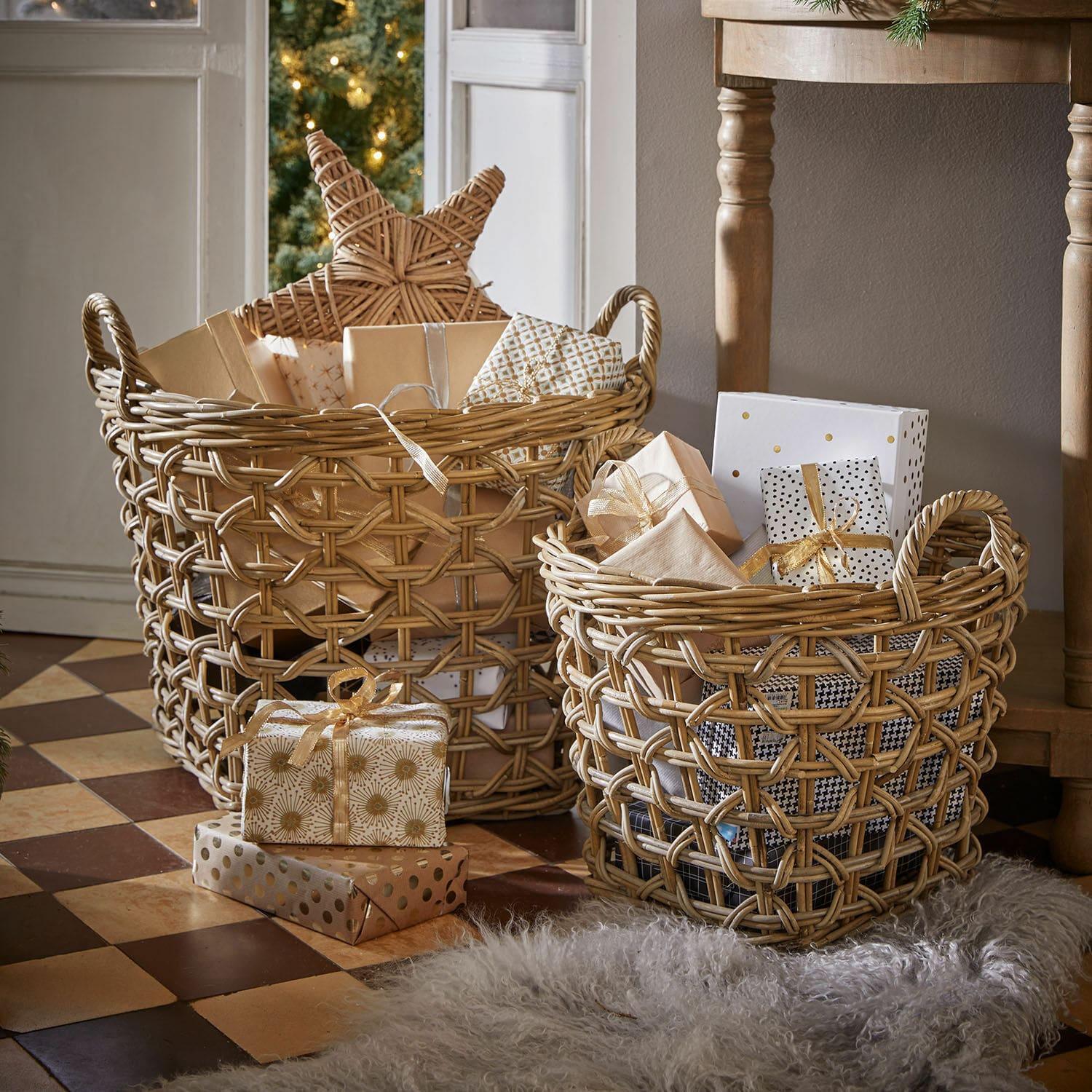 Korb 2er Set Qivoran Zwei naturfarbene Rattankörbe mit Geschenken und Weihnachtsdeko auf gefliestem Boden.