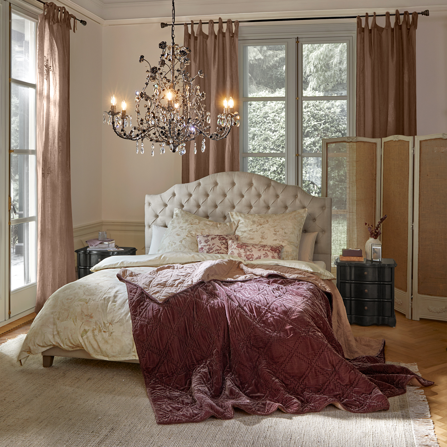 Gemütliches Schlafzimmer mit beige gepolstertem Kopfteil und bordeauxroter Samtdecke auf dem Bett