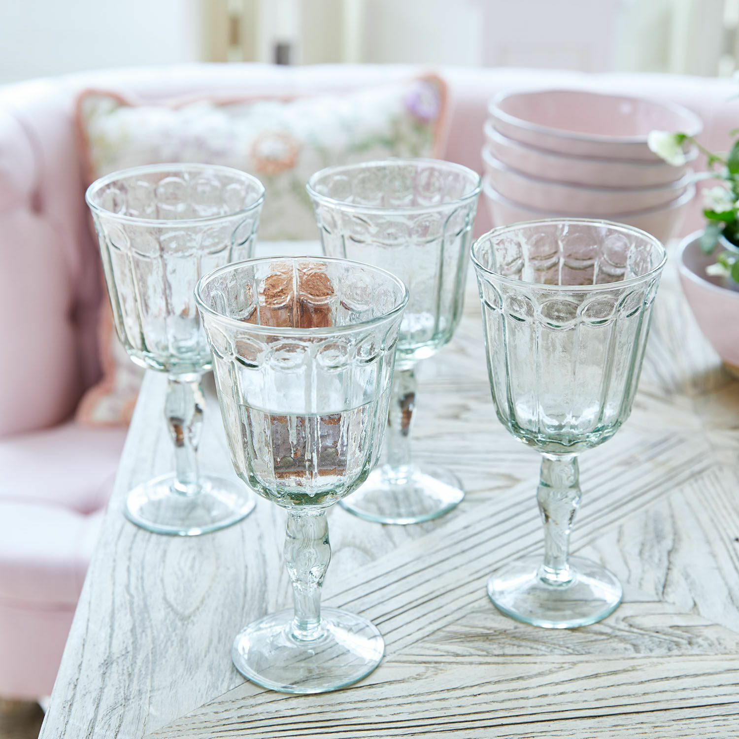 Glas 4er Set Jolielle Vier transparente Gläser mit dekorativem Muster auf Holz-Tisch in hellem Raum