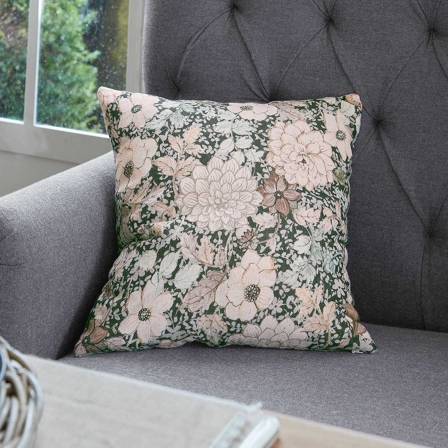 Kissenhülle Cappellina Dekoratives Baumwollkissen mit grün-beigem Blumenmuster auf grauem Sofa