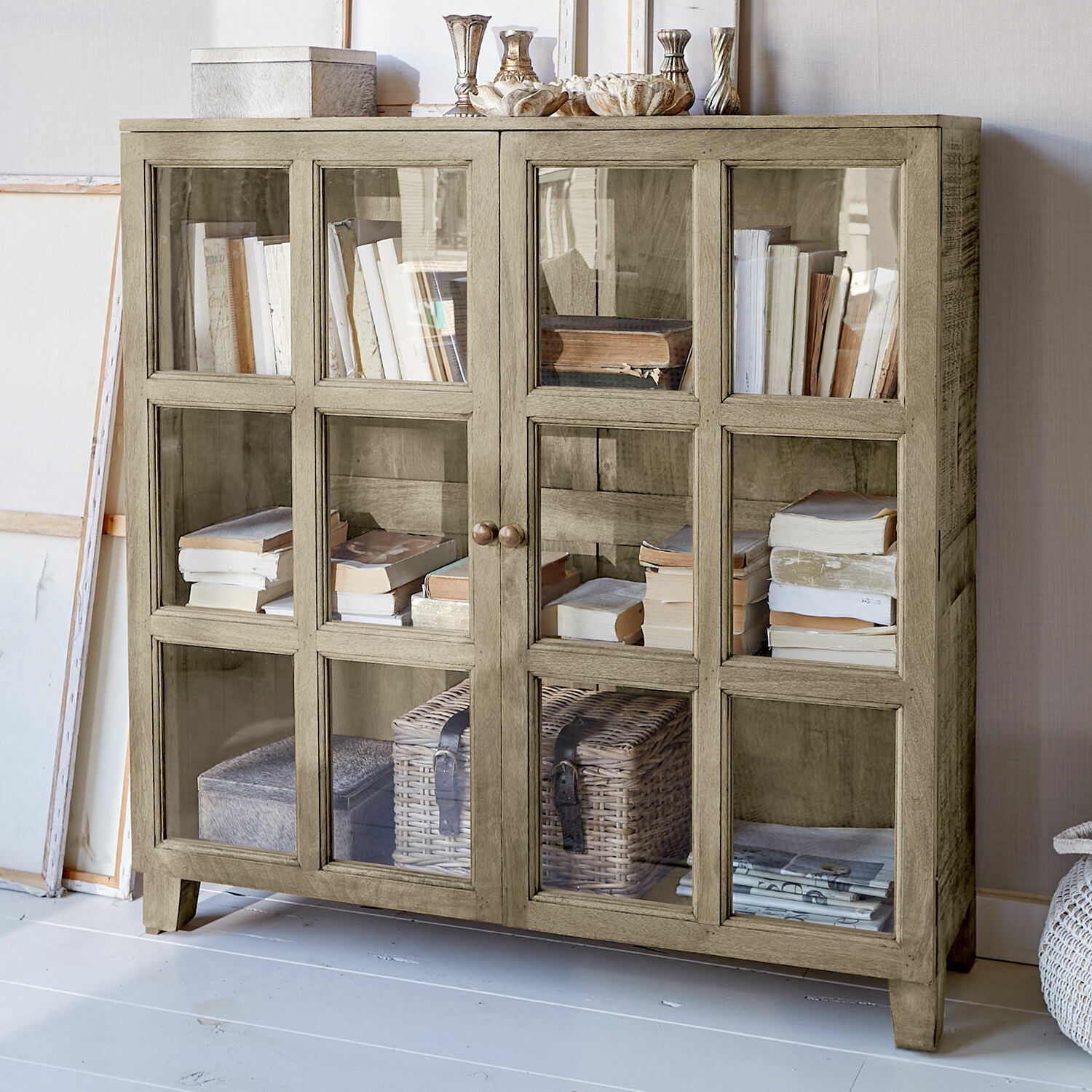 Kommode Stoneham Beige Holzvitrine mit Glastüren, gefüllt mit Büchern und Dekorationen, stilvolles Wohnzimmermöbel