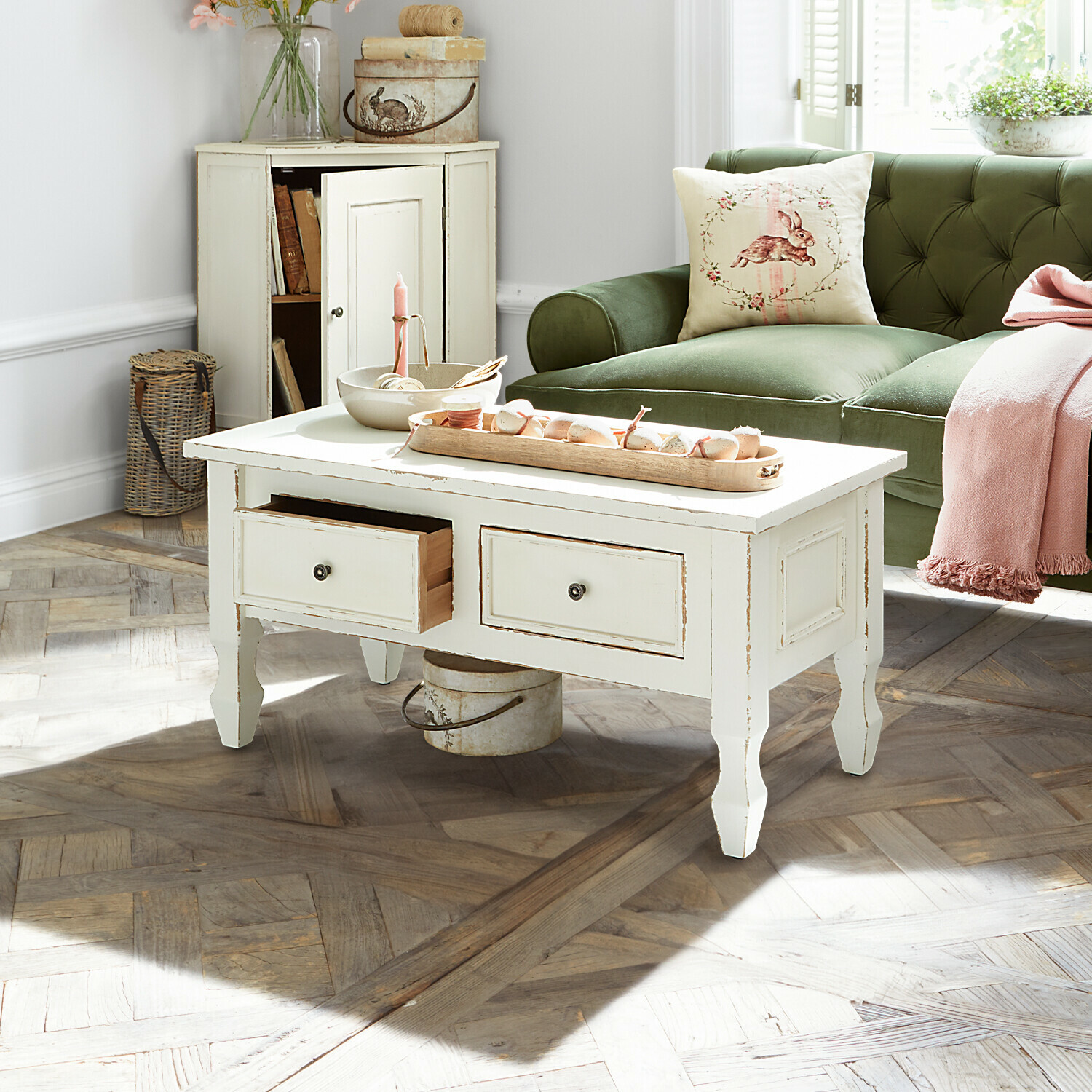 Weißer Holztisch im Vintage-Stil mit Schubladen in hellem Wohnzimmer mit grünem Sofa