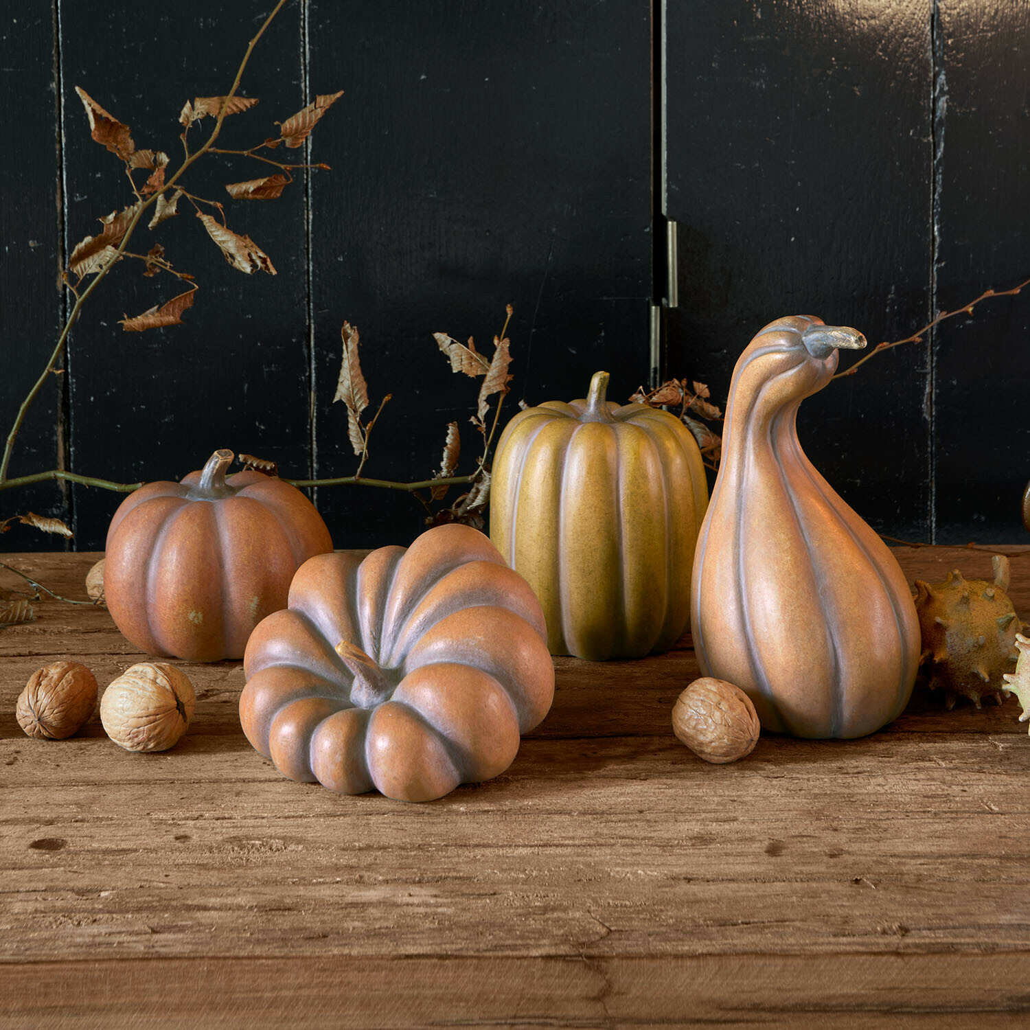 Deko-Kürbis 4er Set Mavoreta Dekorative Keramik-Kürbisse in Braun- und Grüntönen auf Holztisch mit Walnüssen