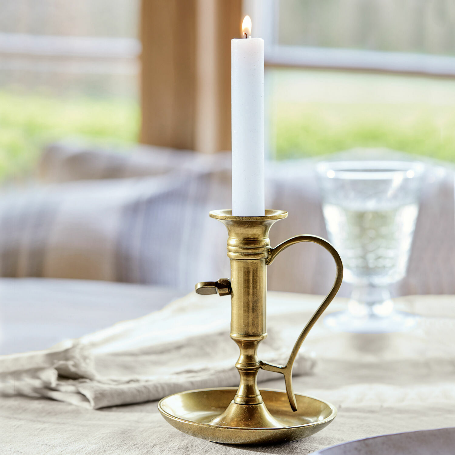 Kerzenständer Carmel Messing-Kerzenhalter mit Griff und weißer Kerze auf Leinentischdecke, Tischdekoration
