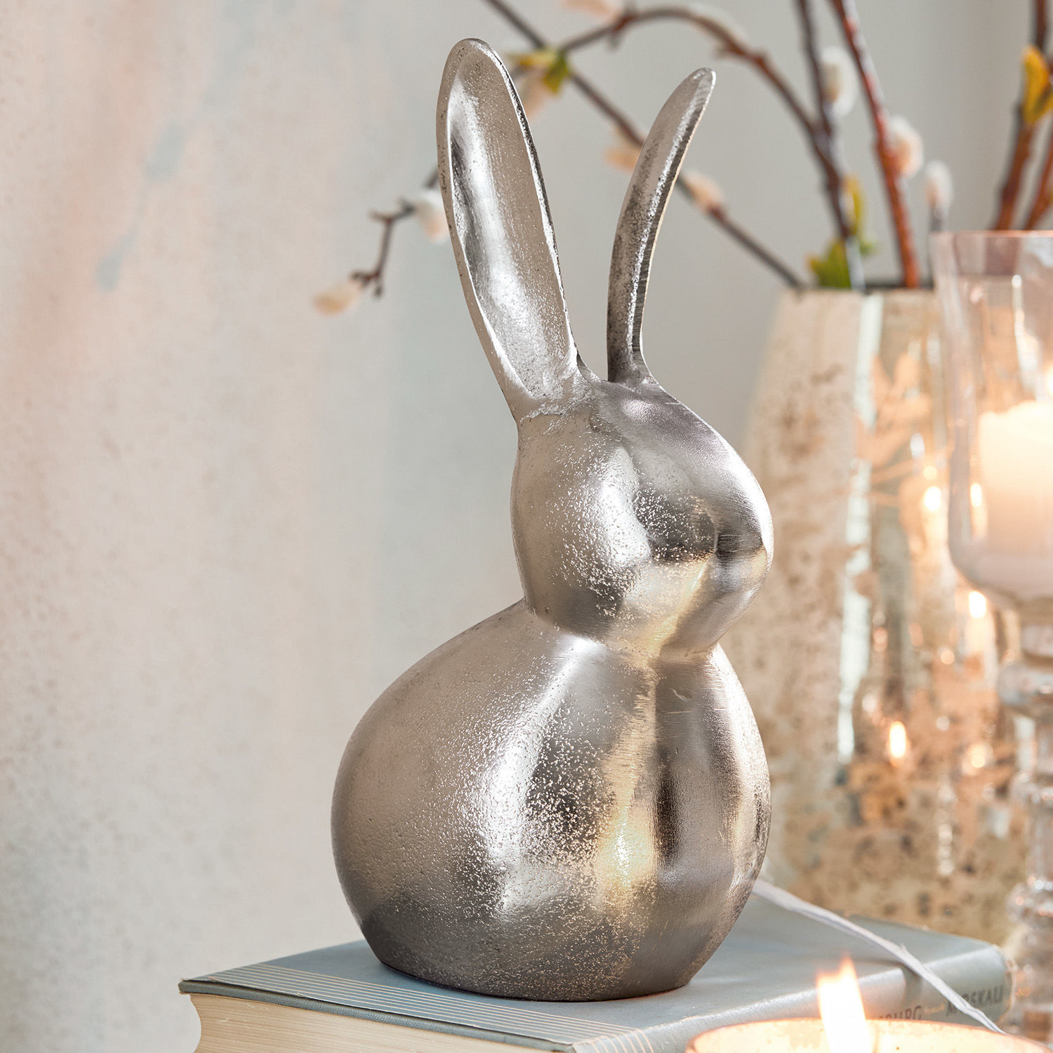 Deko-Hase Benji Dekorativer silberner Metall-Hase auf Buch, Osterdeko für das Zuhause