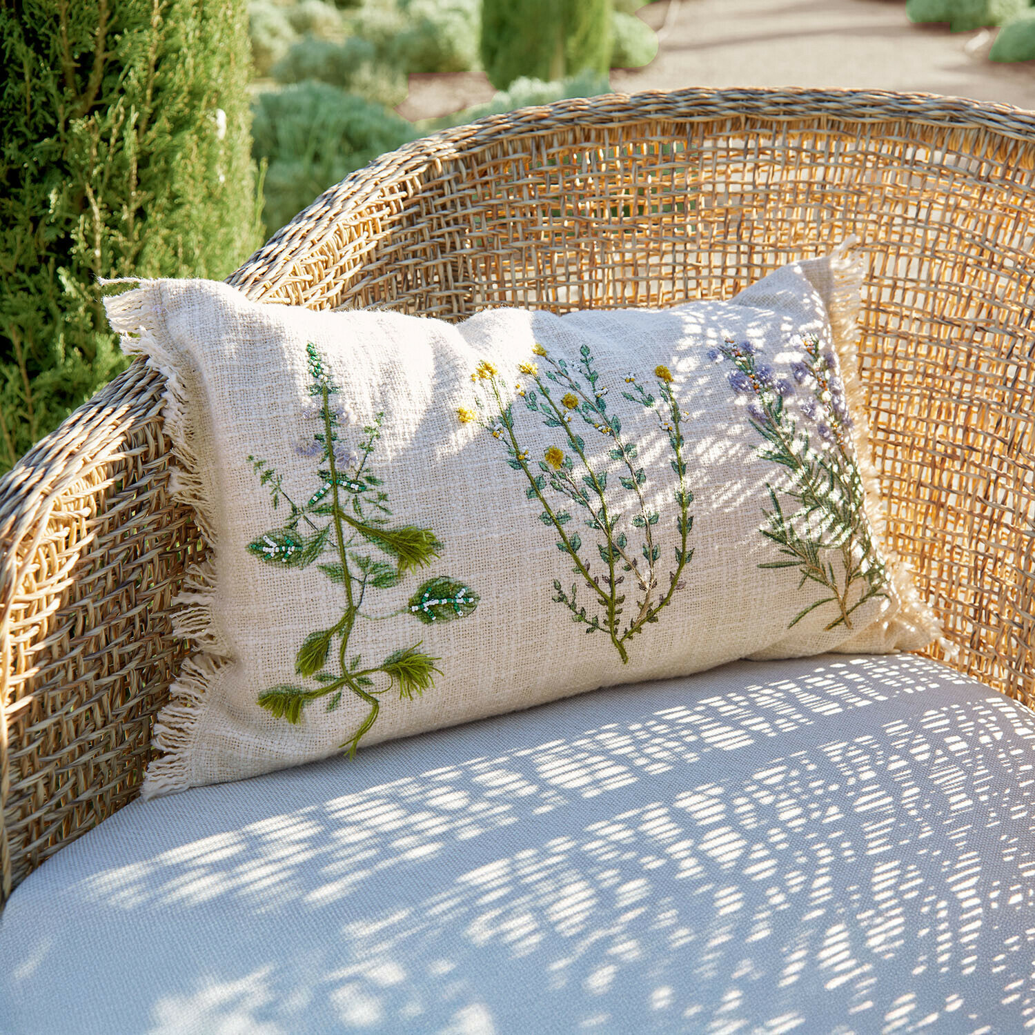Kissenhülle Sélomiane Beige Leinenkissen mit Pflanzenstickerei auf Rattansessel, Gartendekoration
