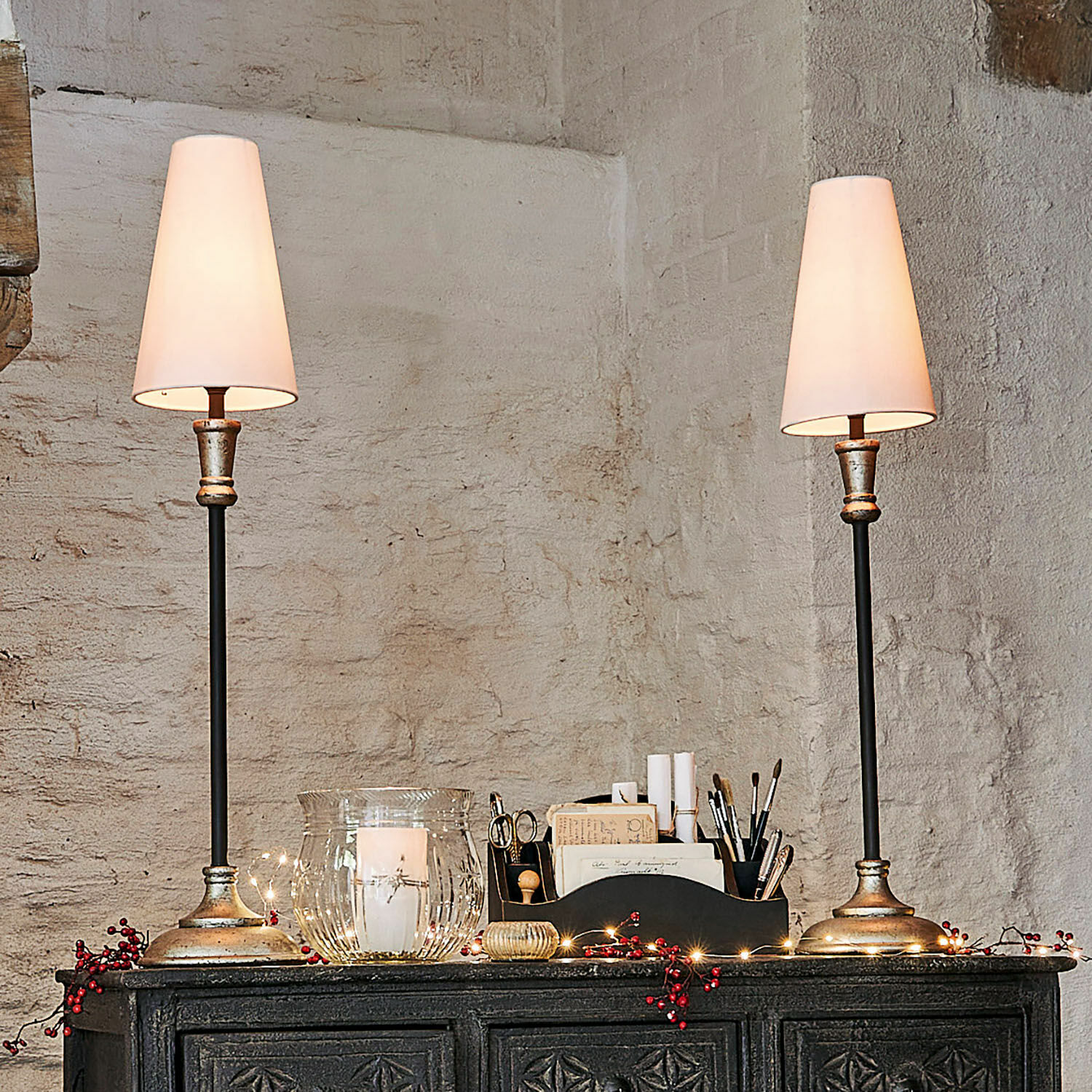 Tischlampe 2er Set Obsonville Paar Tischlampen mit Metallfuß und weißen Lampenschirmen auf dunklem verziertem Sideboard