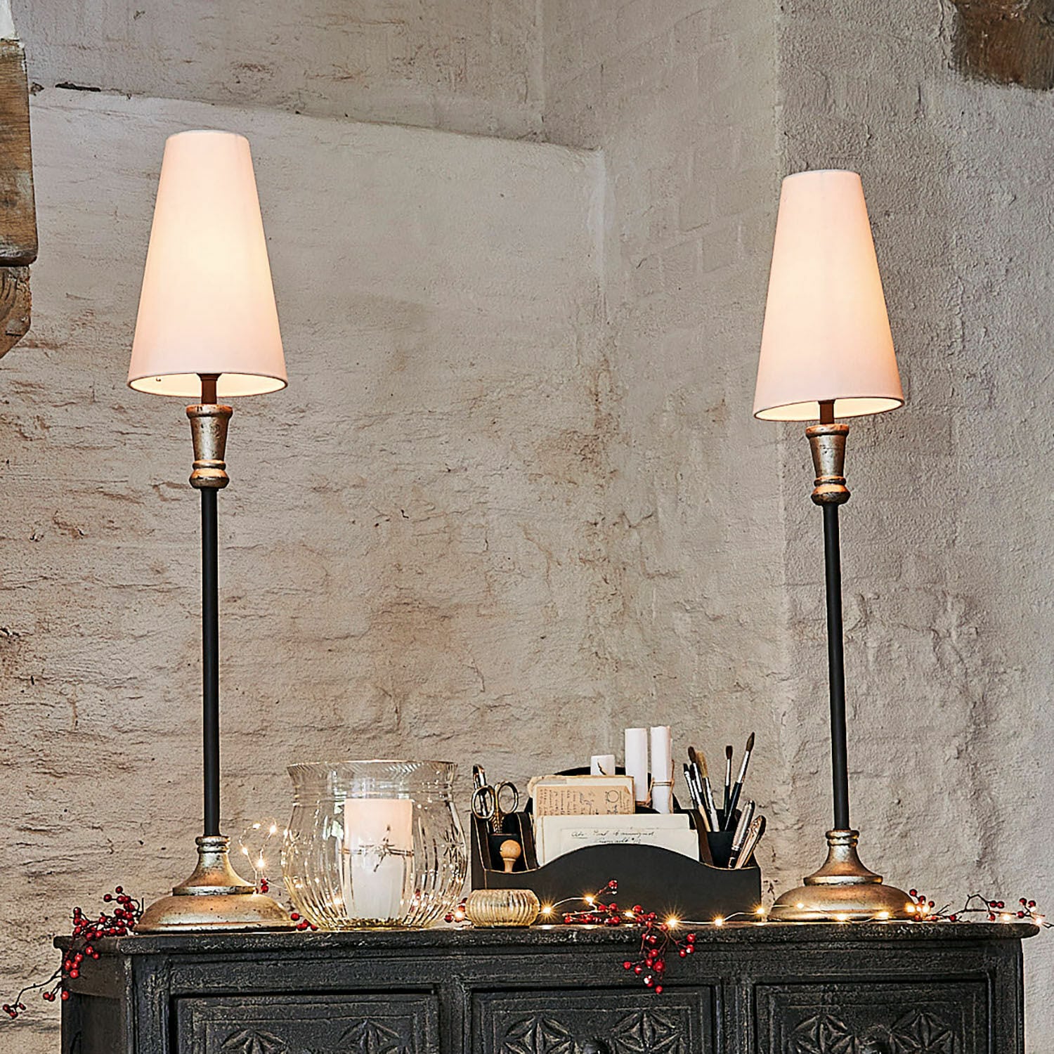 Tischlampe 2er Set Obsonville Paar Tischlampen mit Metallfuß und weißen Lampenschirmen auf dunklem verziertem Sideboard