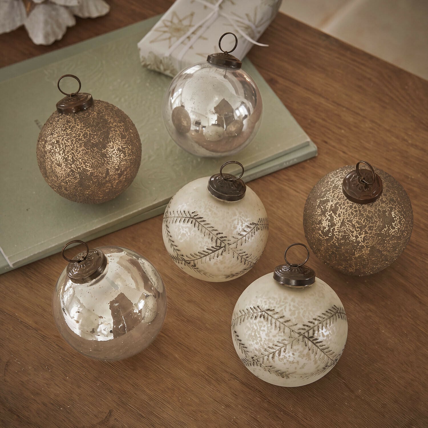Weihnachtskugel 6er Set Fioravino Set aus sechs goldfarbenen Weihnachtskugeln aus Glas mit verschiedenen Oberflächen auf Holztisch