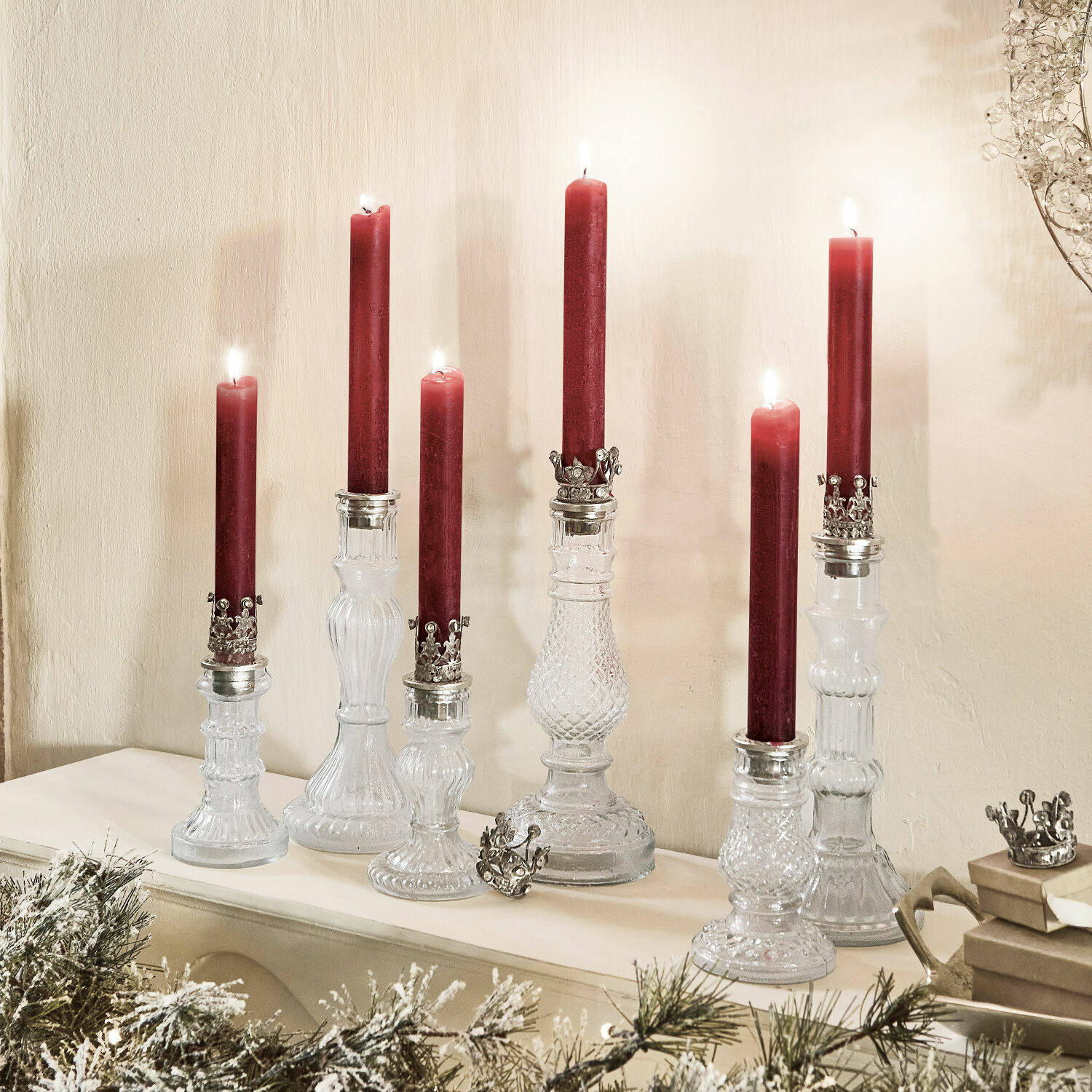 Kerzenständer 6er Set Youna Set aus gläsernen Kerzenhaltern mit roten Kerzen und Metallverzierungen auf Kaminsims