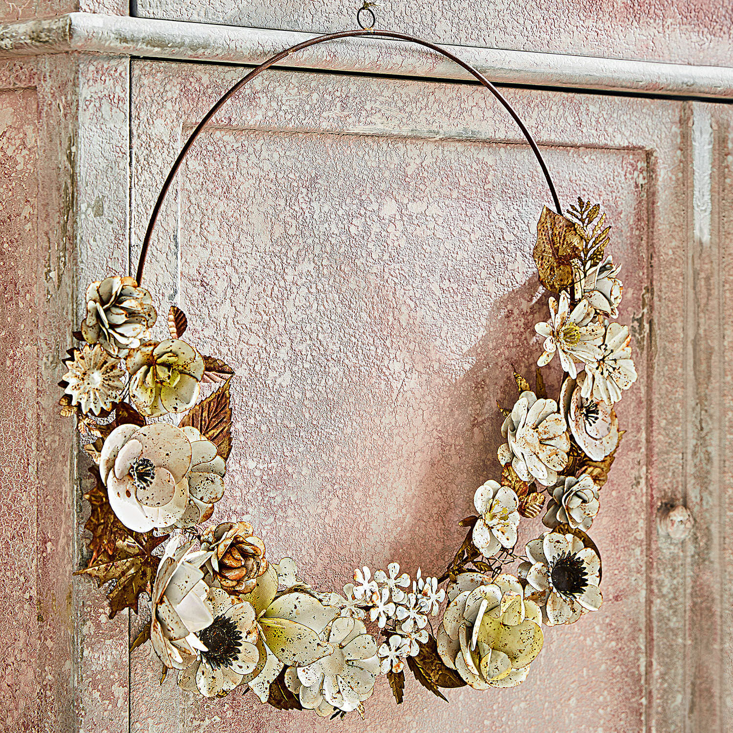 Dekorativer Metallkranz mit cremefarbenen Blumen, stilvolle Wanddekoration für Zuhause