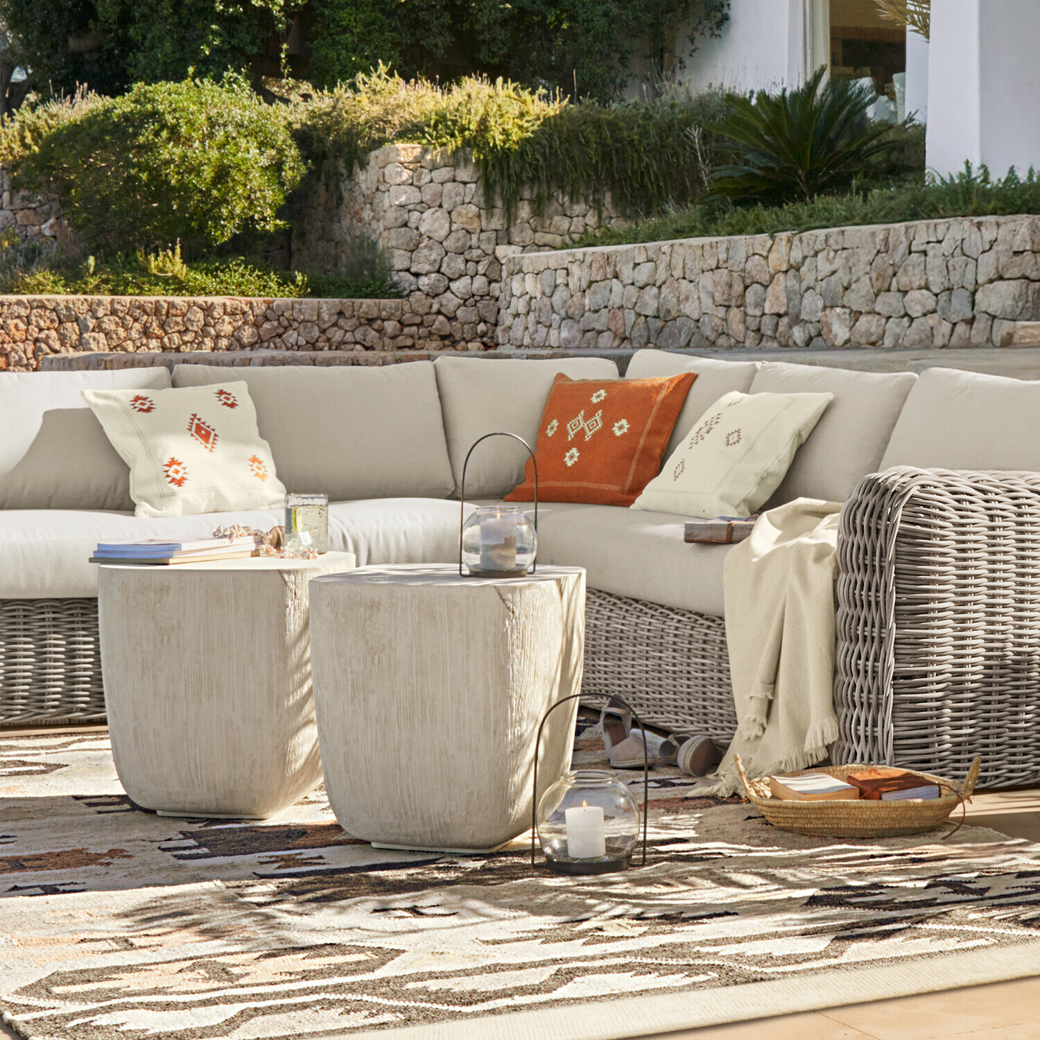 Ecksessel Eravinto Outdoor-Möbelset mit beigem Rattansofa und zwei hellen Beistelltischen auf Terrasse