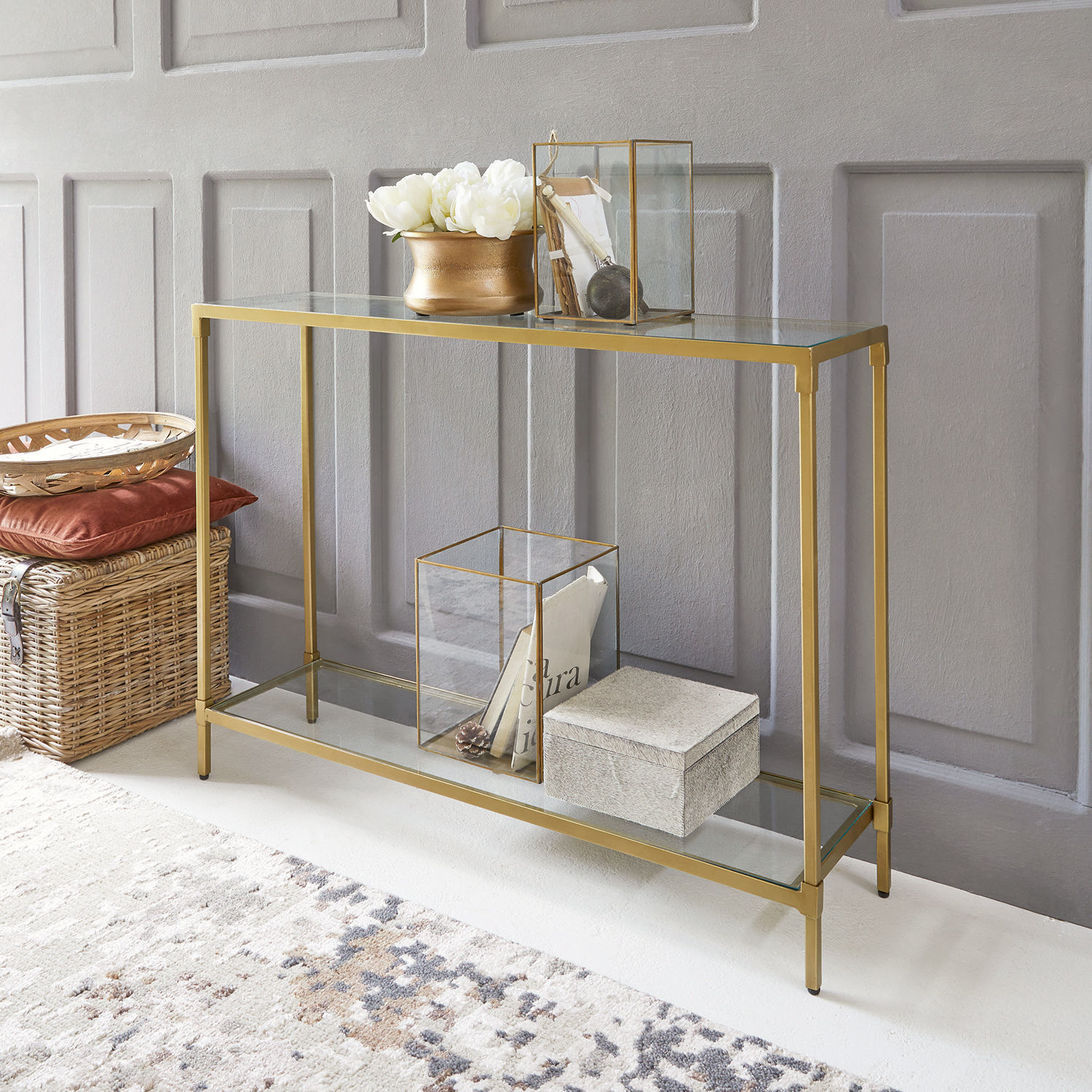 Konsole Ninove Glas-Konsole mit goldenem Metallrahmen, Dekorationen und Korb aus Weide auf dem Boden