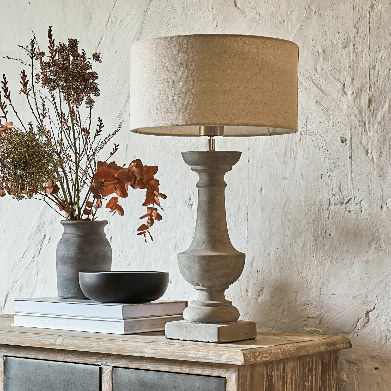 Tischlampe Tifaine Tischlampe aus Beton mit beigem Lampenschirm auf Holzkommode mit Dekoration