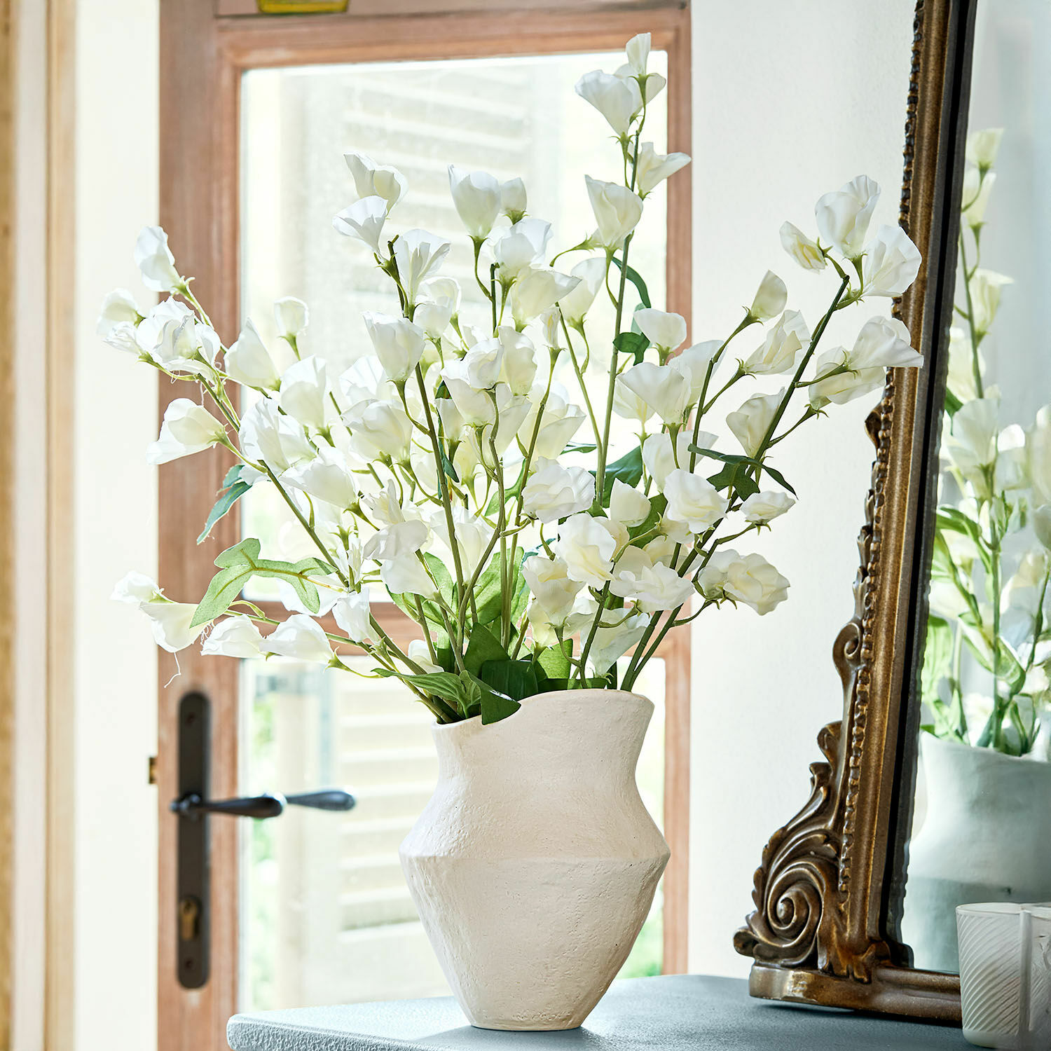 Blume 6er Set Clavigny Weiße Keramikvase mit weißen Dekoblumen auf Tisch neben einem antiken Spiegel