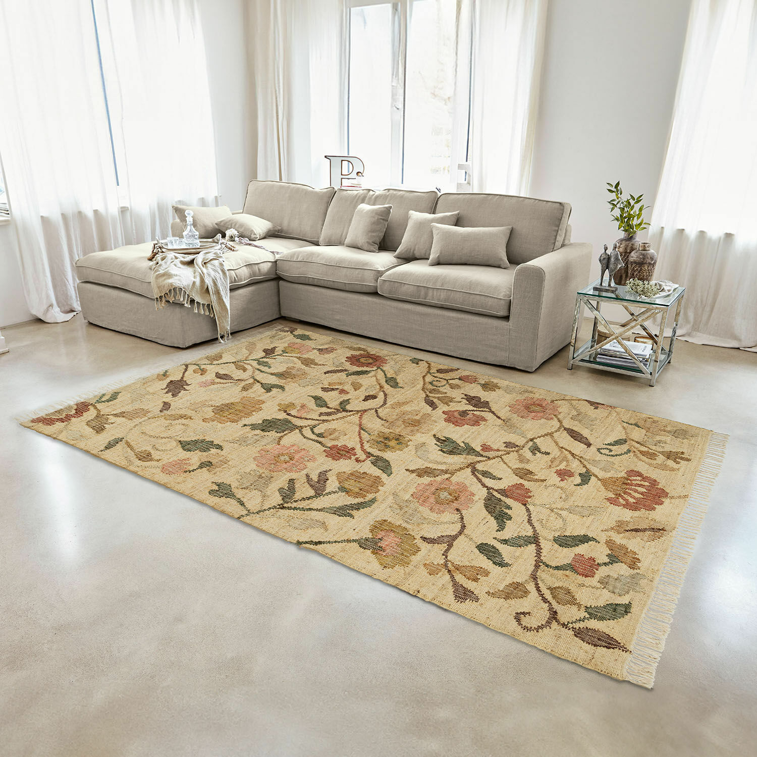 Beigefarbener Teppich mit floralem Muster aus Naturmaterial im hellen Wohnzimmer mit grauem Sofa