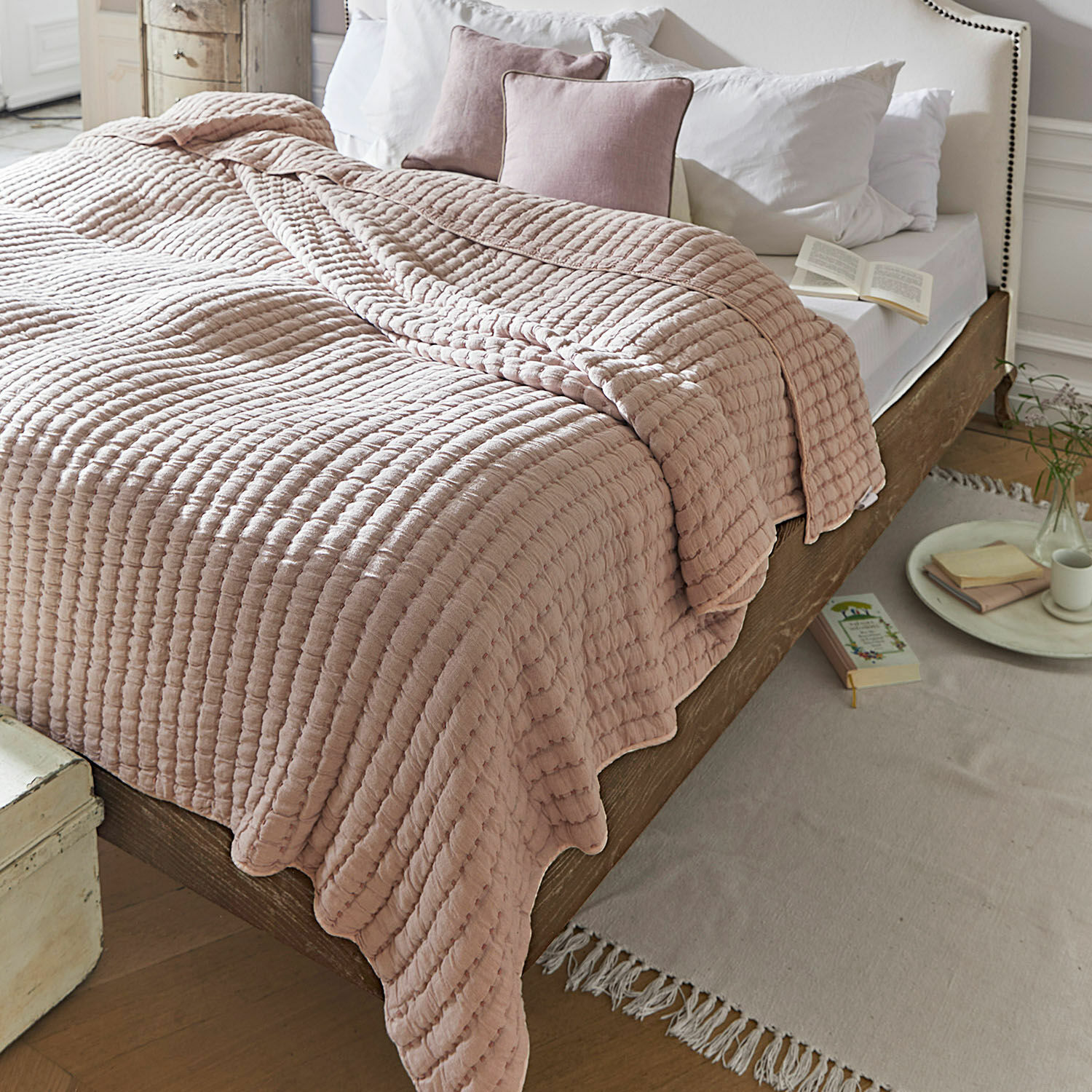 Quilt Herepian Rosa gesteppte Baumwolldecke auf Holzbett mit weißer Bettwäsche in gemütlichem Schlafzimmer