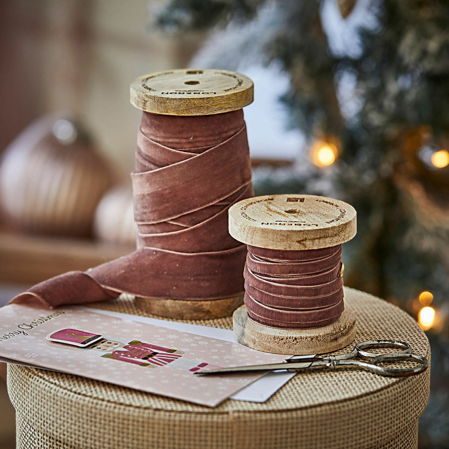 Samtband 2er Set Liandis Zwei Holzspulen mit rosa Samtband auf Weihnachtstisch neben Schere und Karte