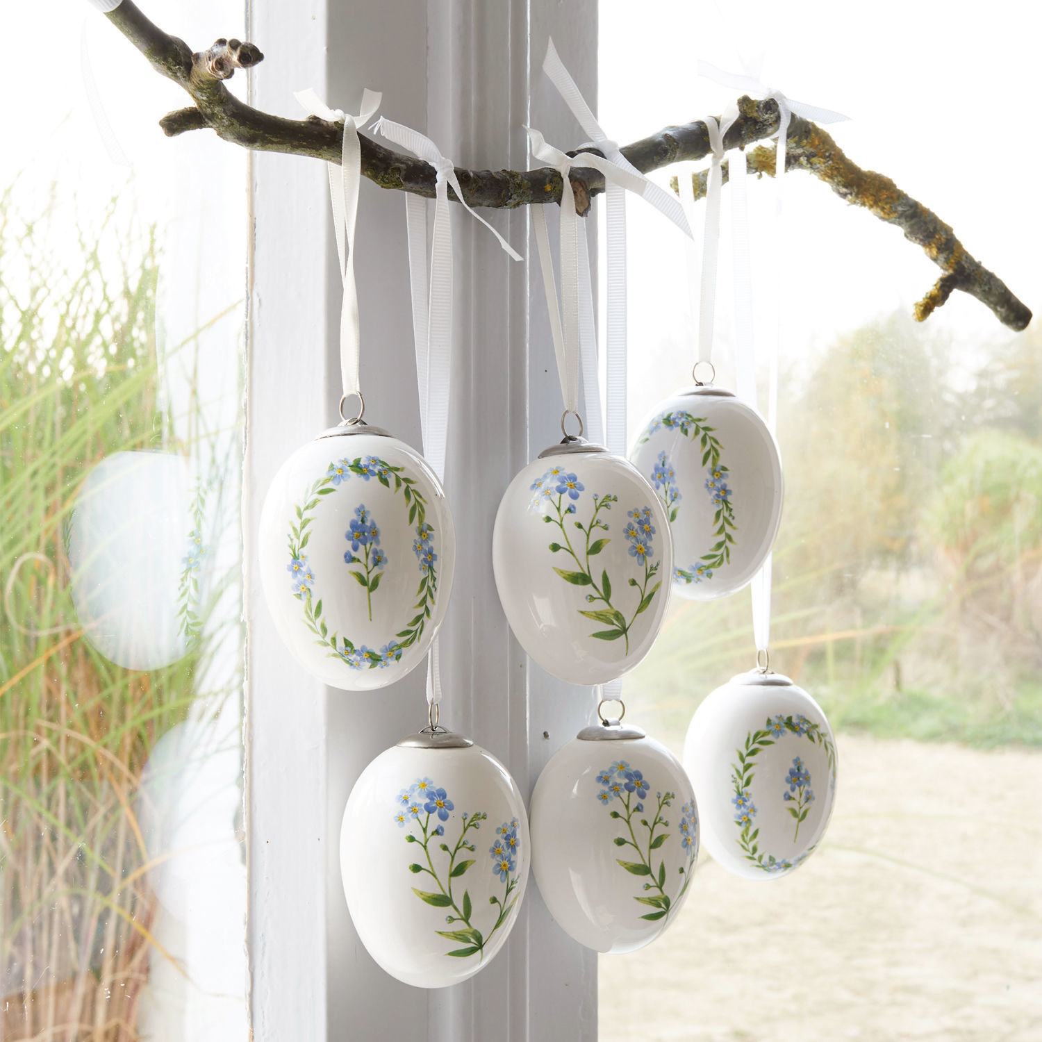 Osterei 6er Set Fierolla Weiße Keramikeier mit blauen Blumen an Zweig hängend, frühlingshafte Fensterdekoration