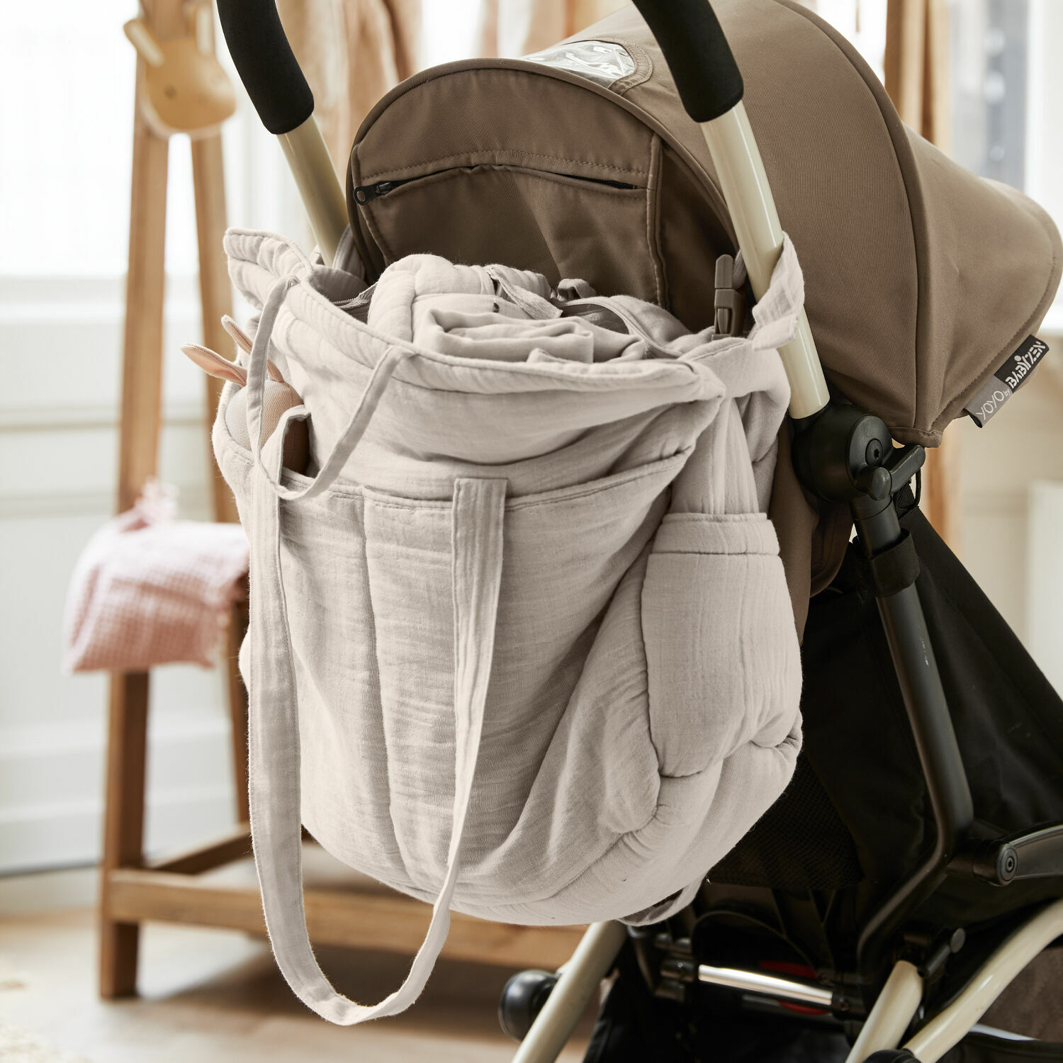 Wickeltasche Mireval Beige Tasche aus weichem Stoff an Kinderwagengriff hängend, praktisches Elternzubehör