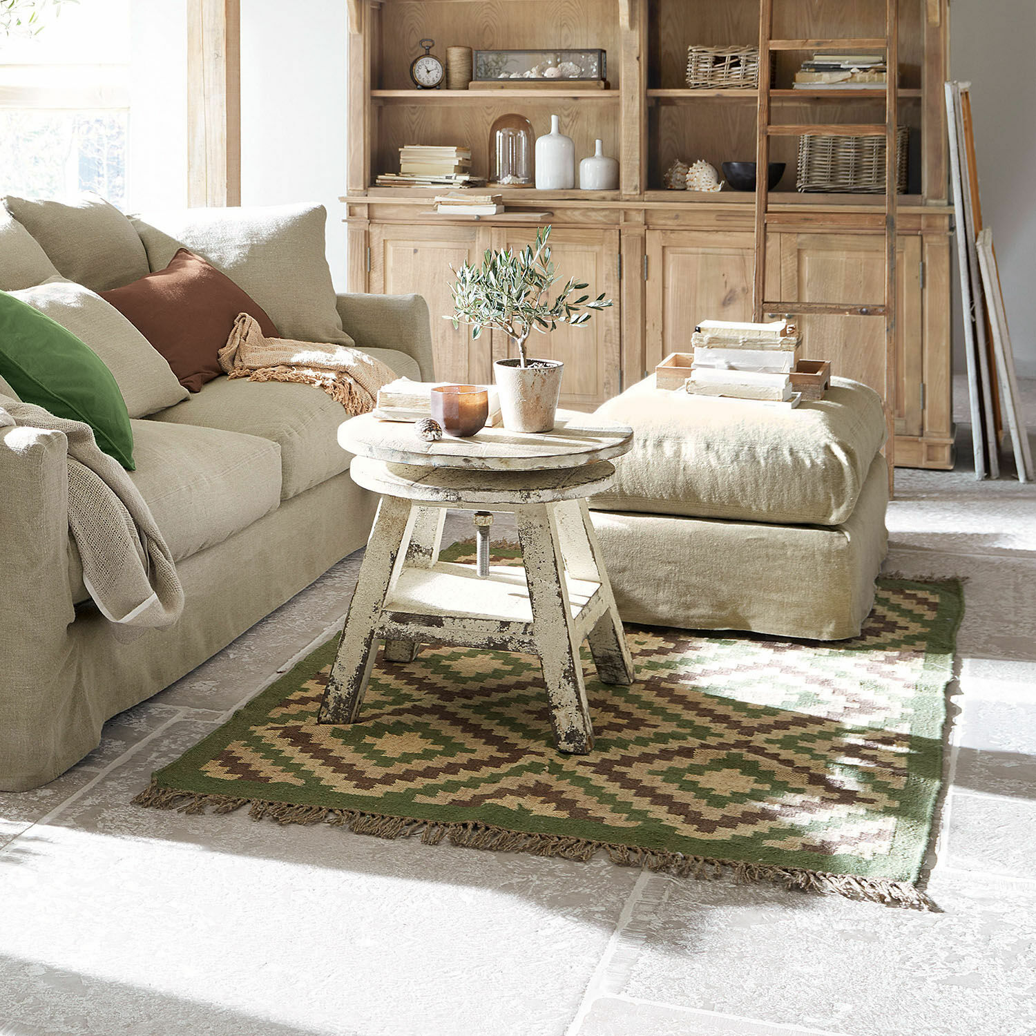 Teppich Dailies Gemütliches Wohnzimmer mit beigem Sofa, antikem Holztisch und grün-braunem Vintage-Teppich