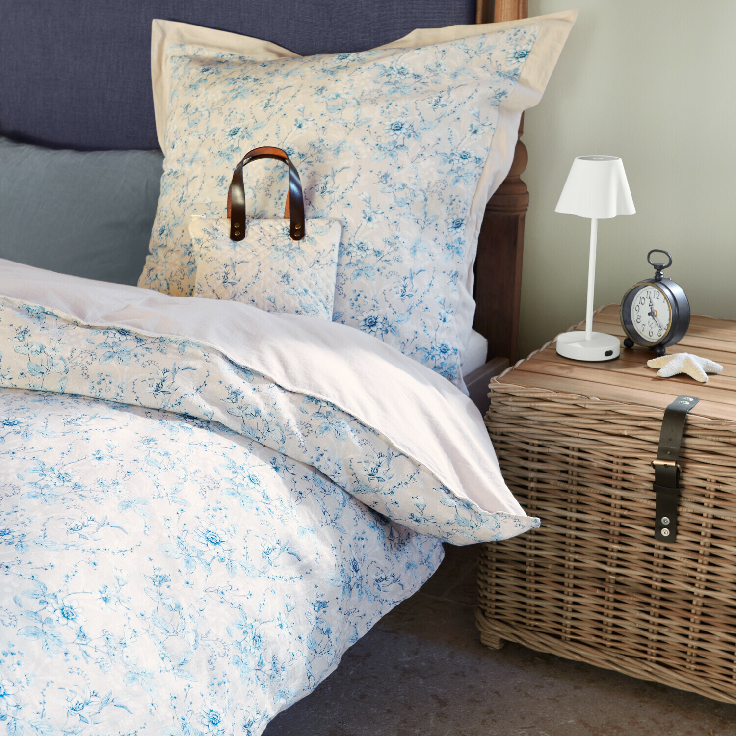 Bettwäsche Vailenne Bettwäsche aus Baumwolle mit hellblauem Blumenmuster auf Bett neben Korbschrank und Lampe