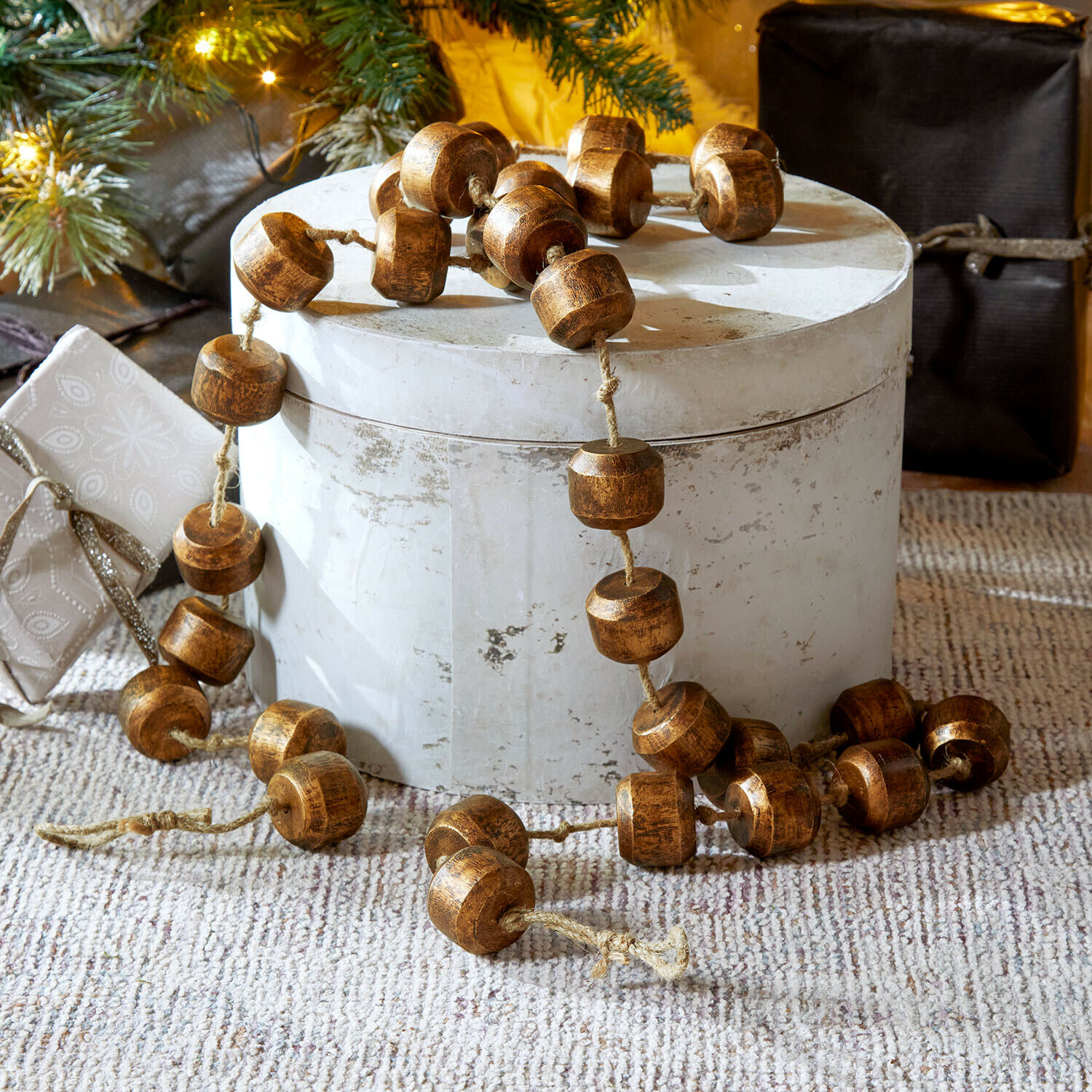 Dekorative Kette aus braunen Holzperlen auf hellem Untergrund, festliche Weihnachtsdekoration