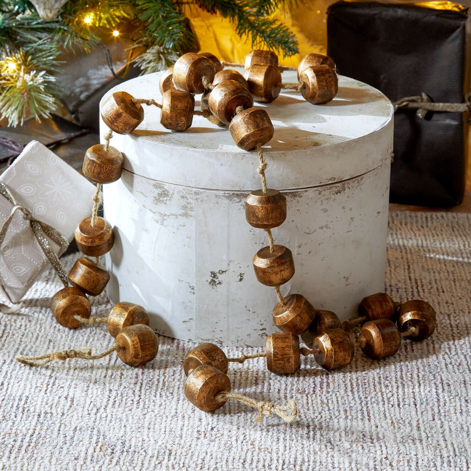 Girlande Caralinas Dekorative Kette aus braunen Holzperlen auf hellem Untergrund, festliche Weihnachtsdekoration