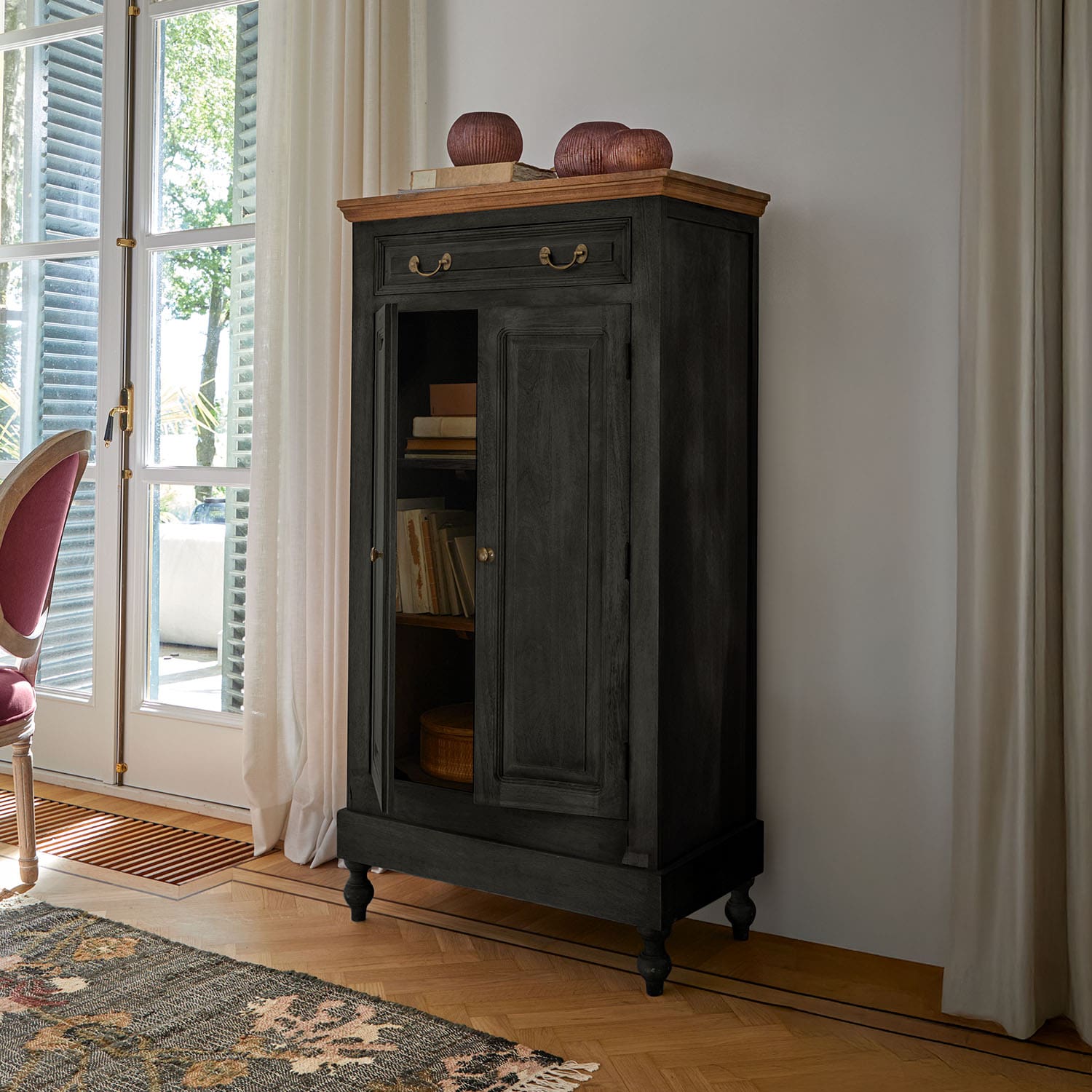 Schwarzer Holzschrank mit hellem Holzdeckel und Messinggriffen in klassischem Wohnzimmer