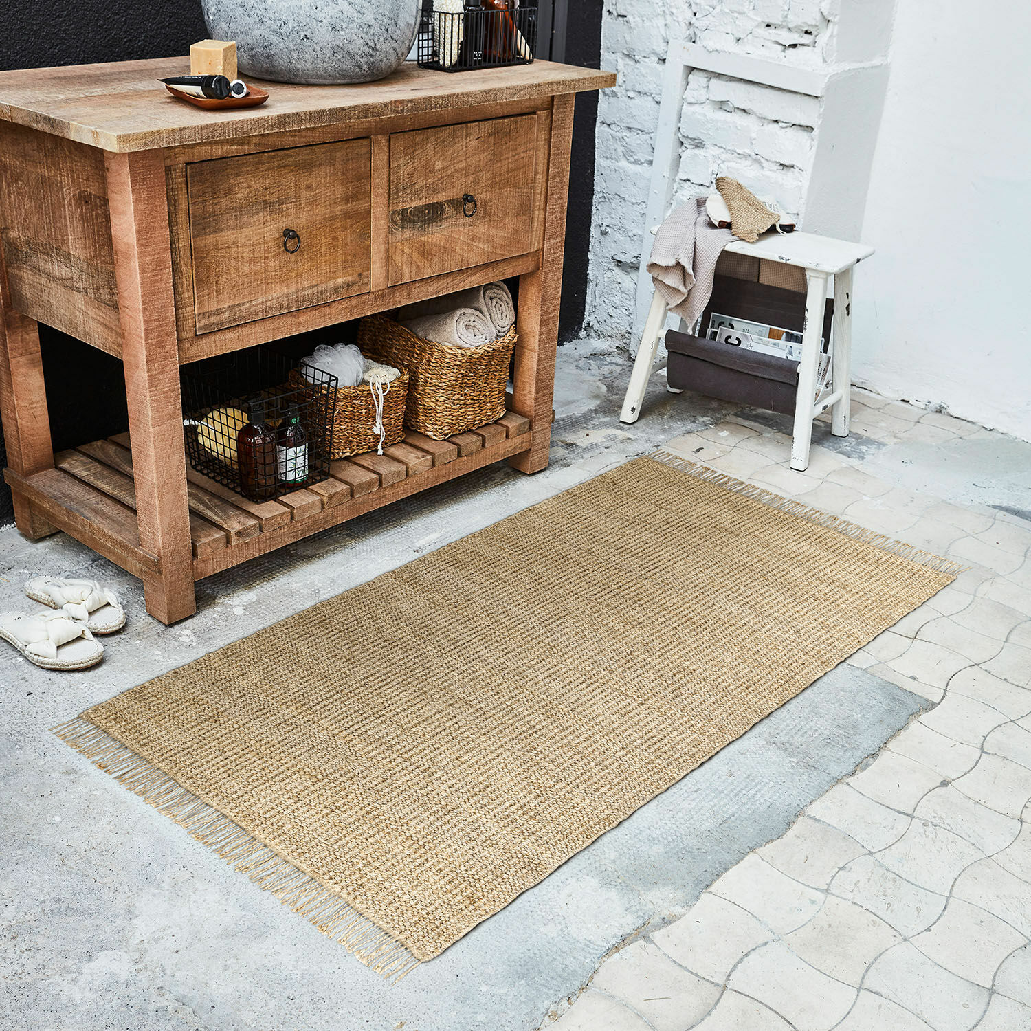 Läufer Hermitage Natürlicher Jute-Teppich in Beige auf Boden neben Holzkommode und weißem Hocker