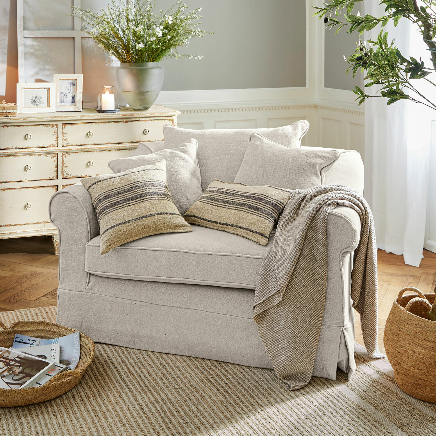 Sessel Folsom Beiges Sofa aus Stoff mit gestreiften Kissen und Decke in gemütlichem Wohnzimmer mit Naturteppich