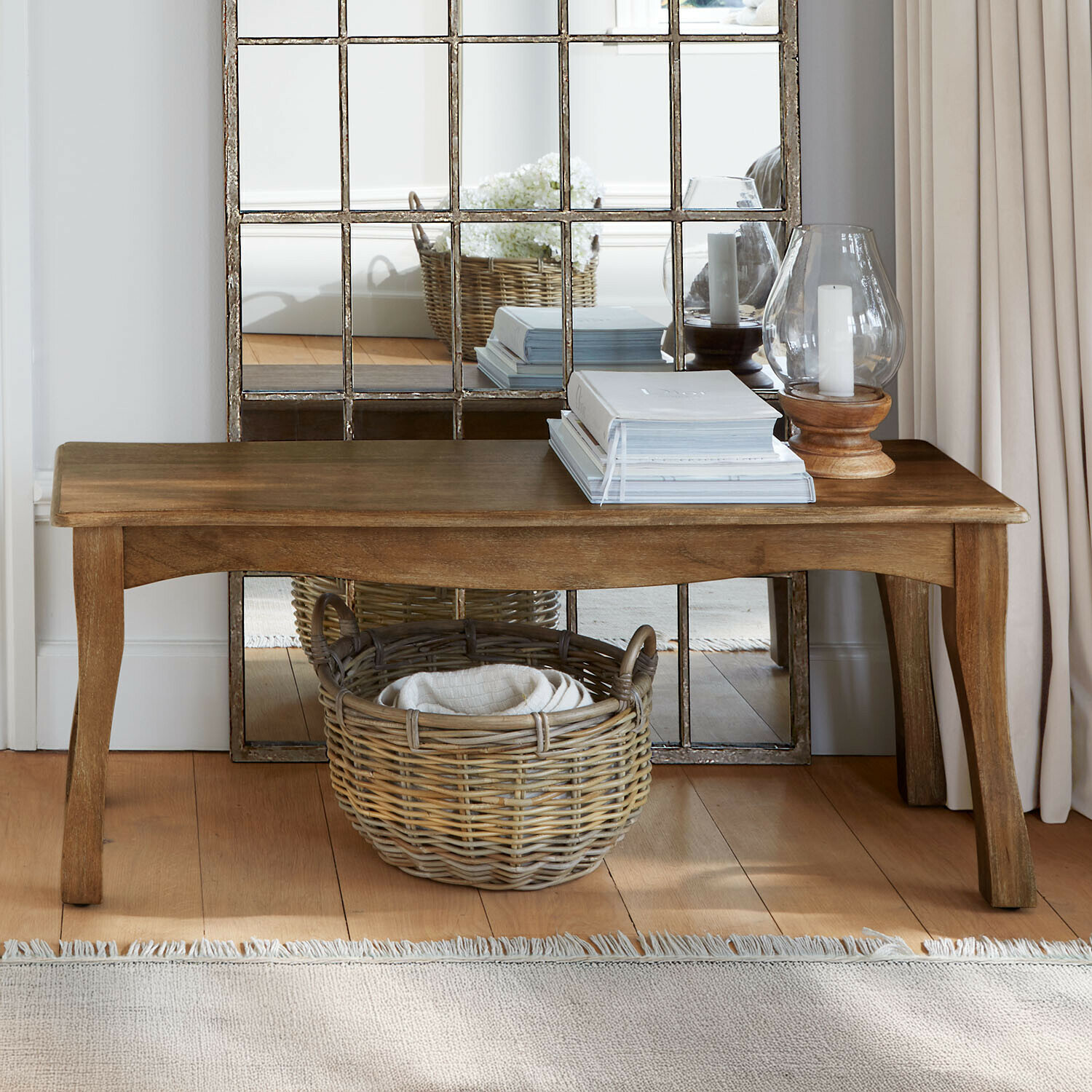 Bank aus Mangoholz in Naturfarbe mit Korb aus Weide und dekorativen Kerzenhaltern