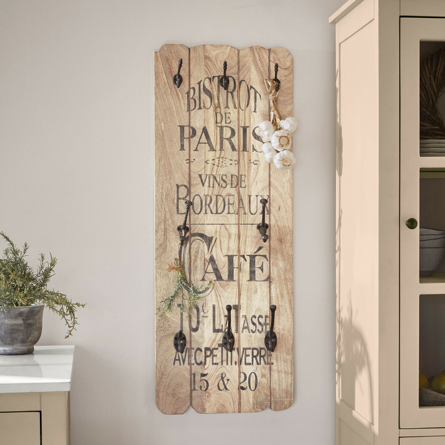 Hakenboard Frélomane Wandgarderobe aus hellem Holz mit schwarzen Metallhaken und französischem Vintage-Schriftzug