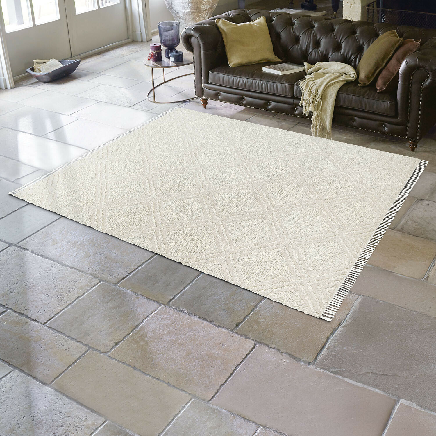 Beiger Teppich mit geometrischem Muster auf Steinboden im Wohnzimmer mit braunem Ledersofa