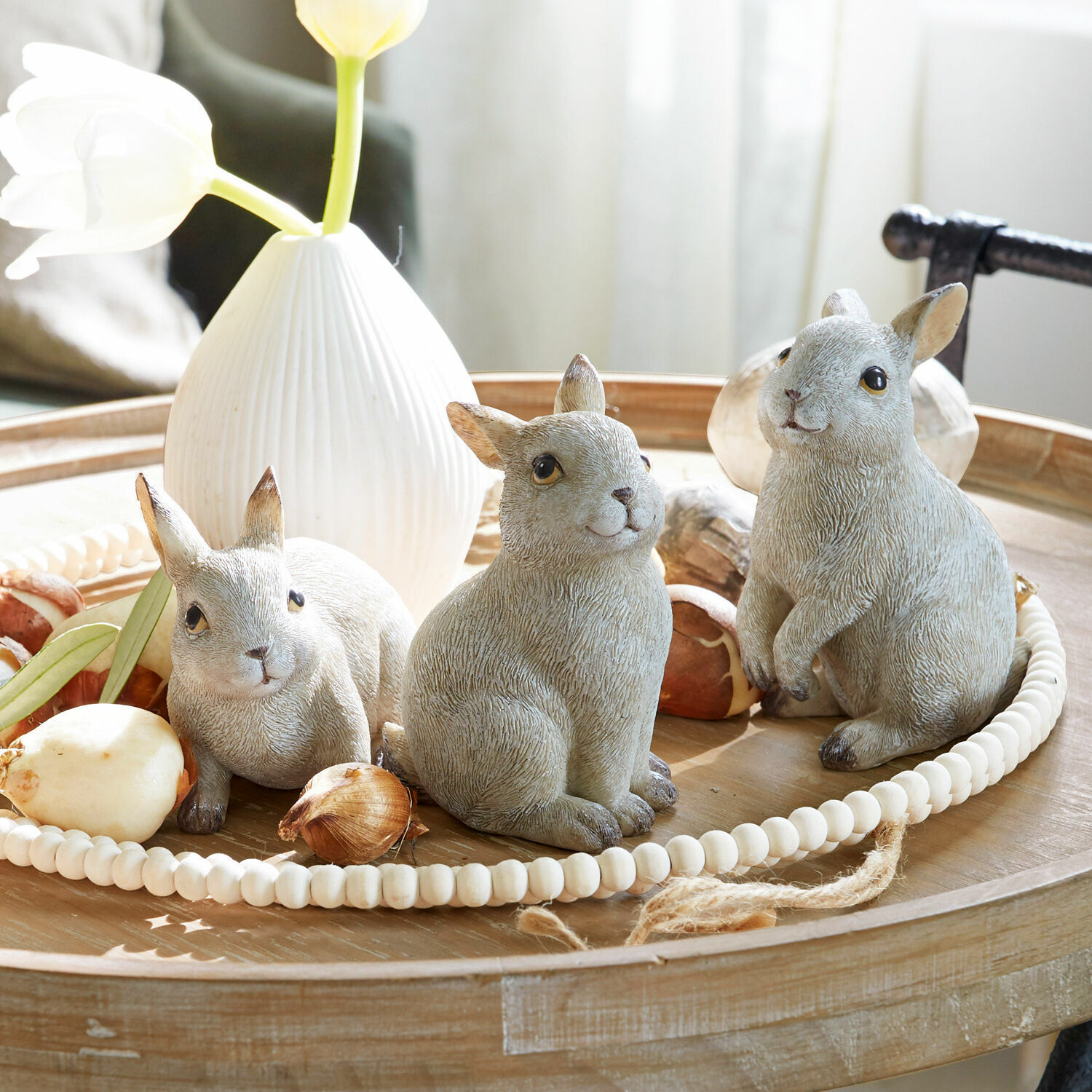 Hase 3er Set Anthony Drei graue Hasenfiguren aus Keramik auf einem Holztablett mit weißer Vase und Blumenzwiebeln