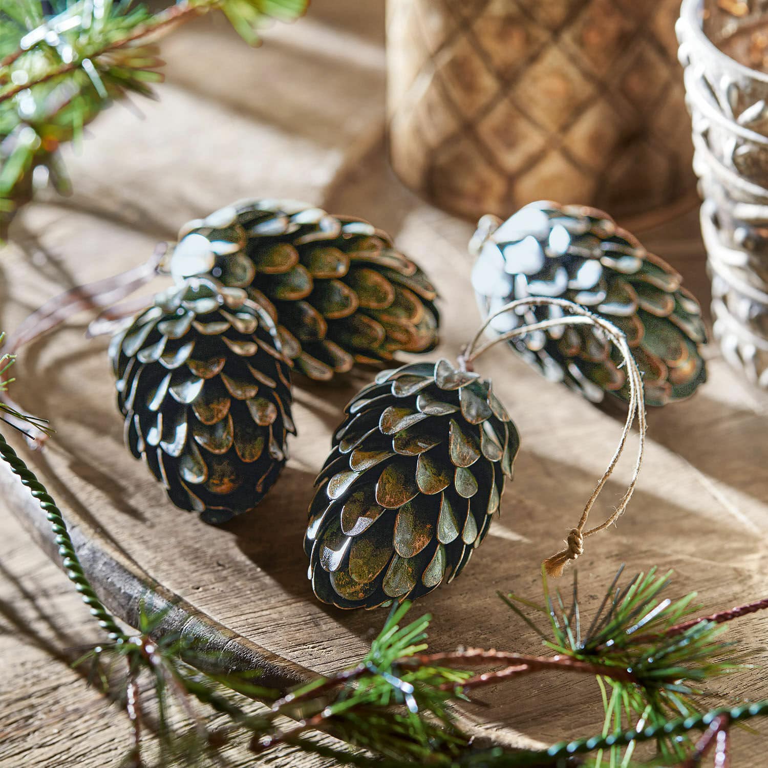 Anhänger 4er Set Lonrai Dunkle Metall-Tannenzapfen mit Aufhängung als Weihnachtsdeko auf Holztablett