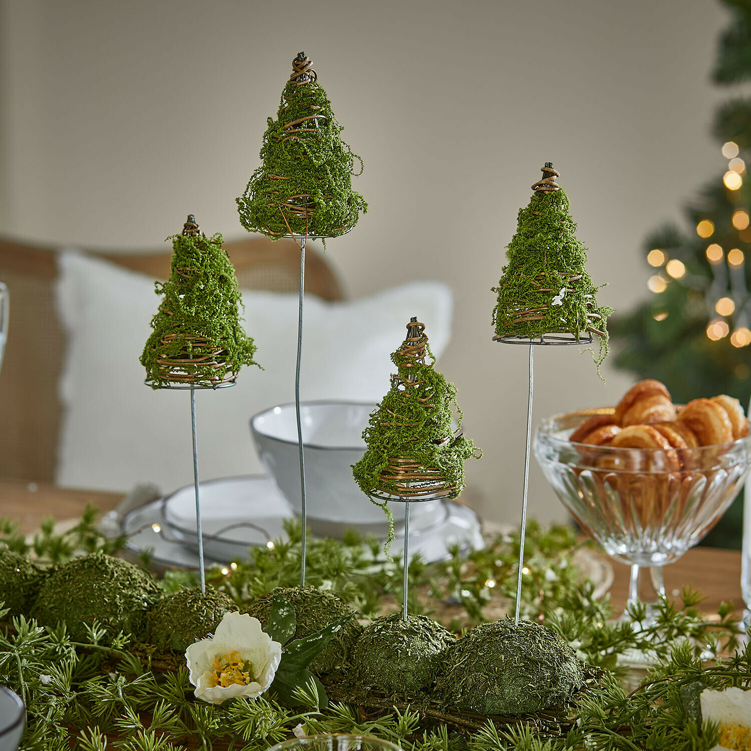 Deko-Baum 4er Set Cassiola Tischdekoration mit grünen Moos-Tannen auf Metallständern in festlicher Atmosphäre