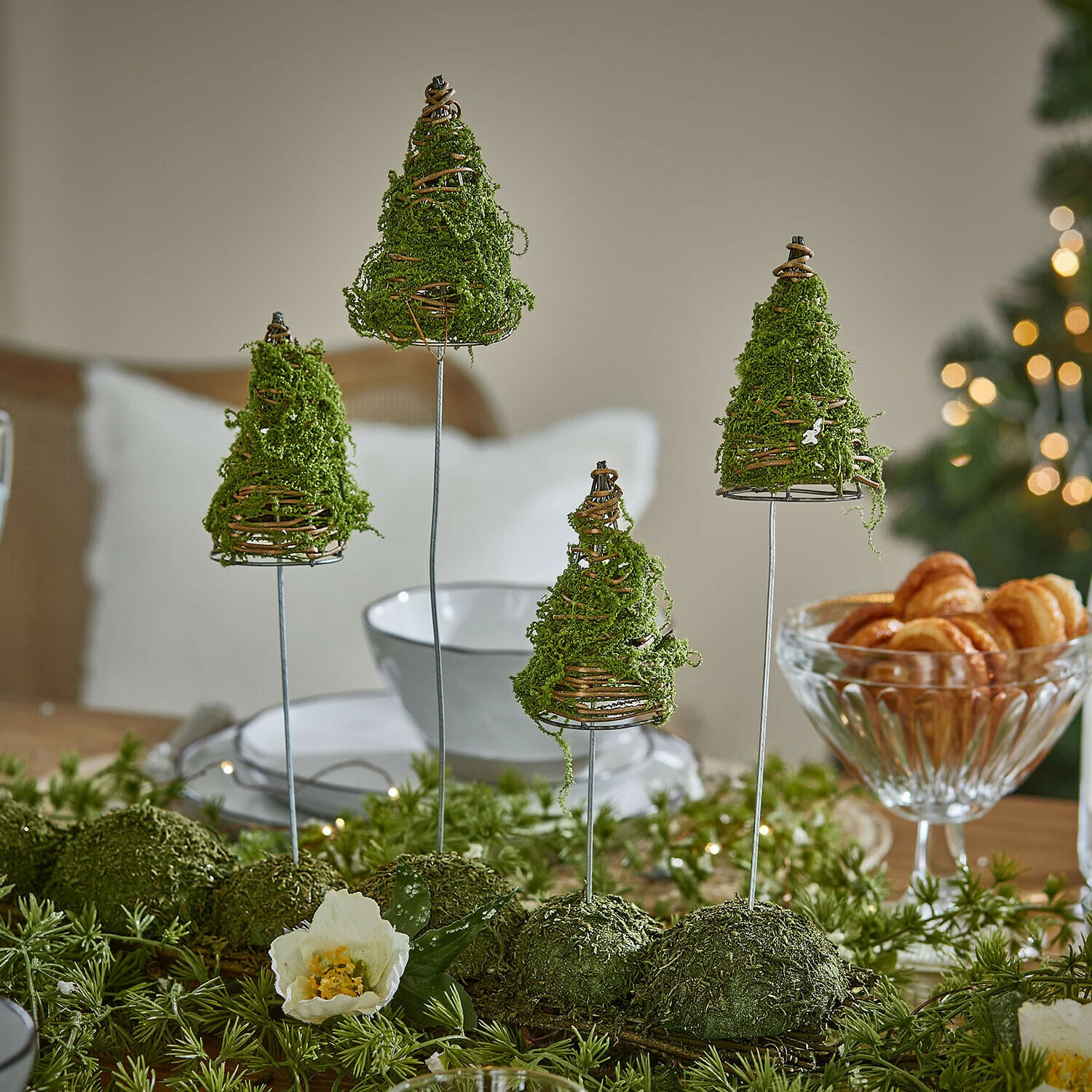 Deko-Baum 4er Set Cassiola Tischdekoration mit grünen Moos-Tannen auf Metallständern in festlicher Atmosphäre