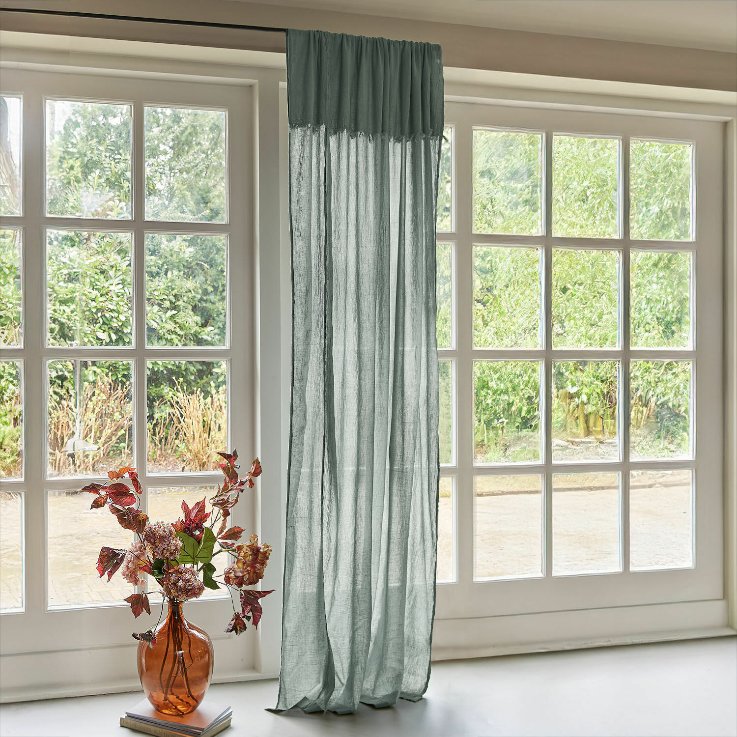 Gardine Dovinel Transparenter grüner Leinenvorhang an großem Fenster mit Gartenblick und Vase mit Blumen