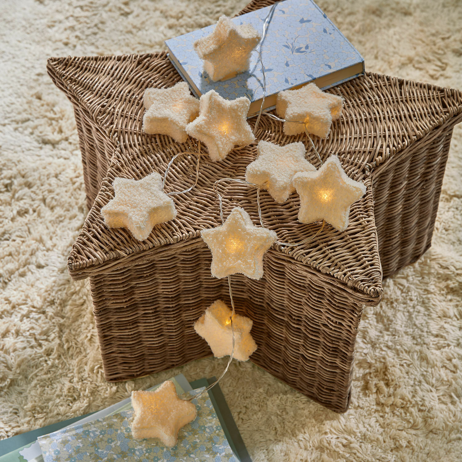 Lichterkette Starwhisper Sternförmige Lichterkette aus weichem Material mit warmem Licht auf einem Korb aus Rattan, Wohnaccessoire