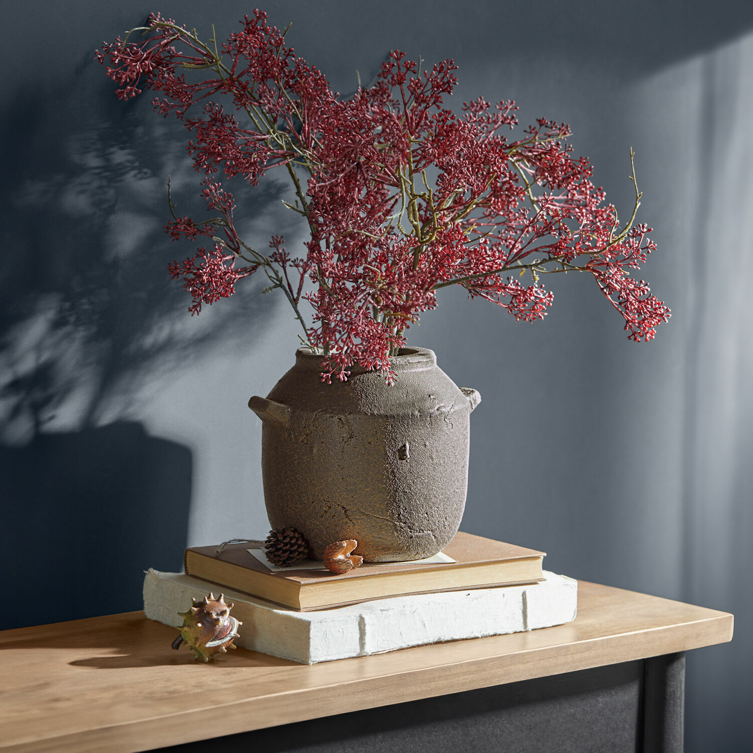 Vase Saintevoux Rustikaler brauner Keramikvase mit roten Zweigen auf Holztisch mit Büchern dekoriert