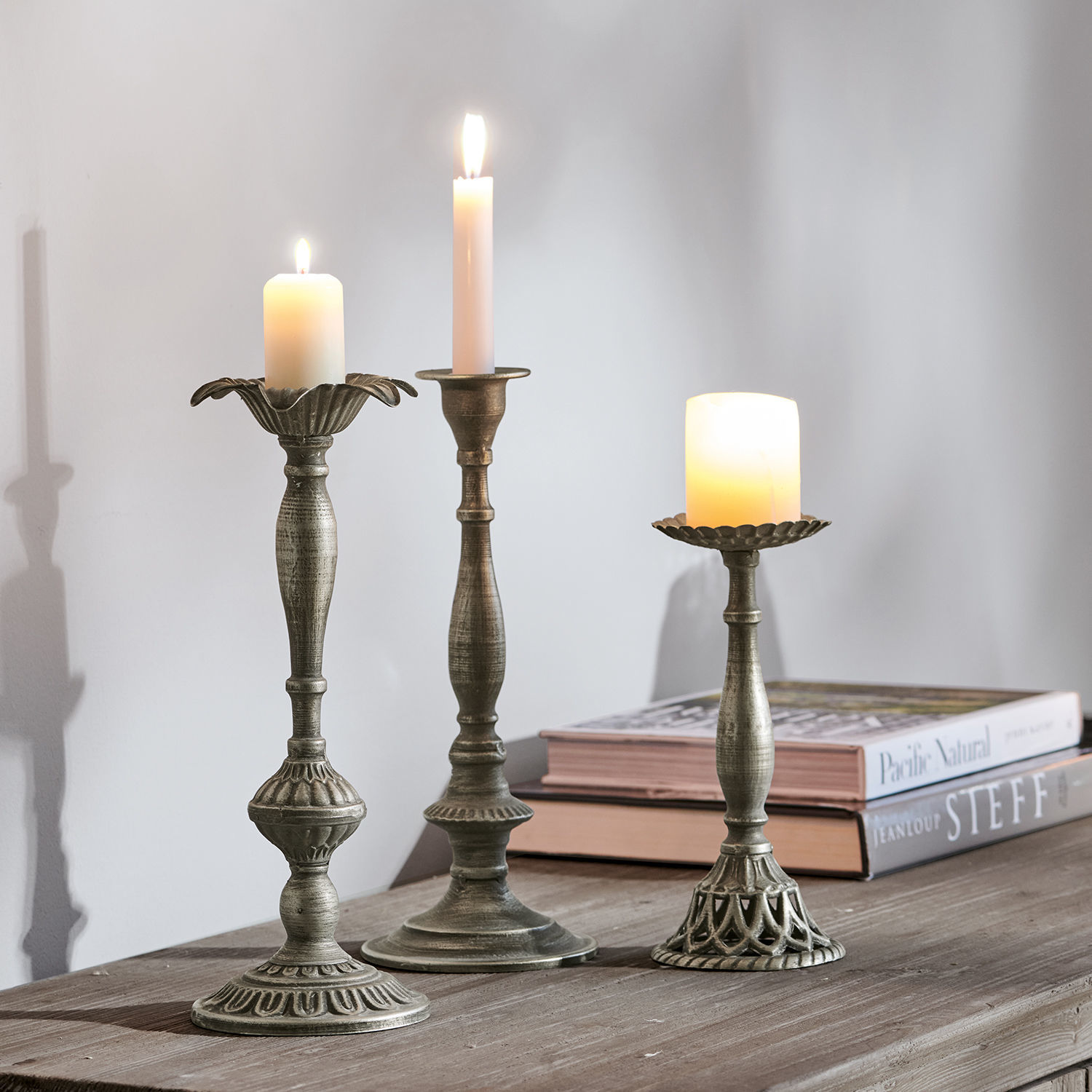 Kerzenständer 3er Set Chandra Drei Kerzenhalter aus Metall in antik-silber mit brennenden Kerzen auf Holztisch