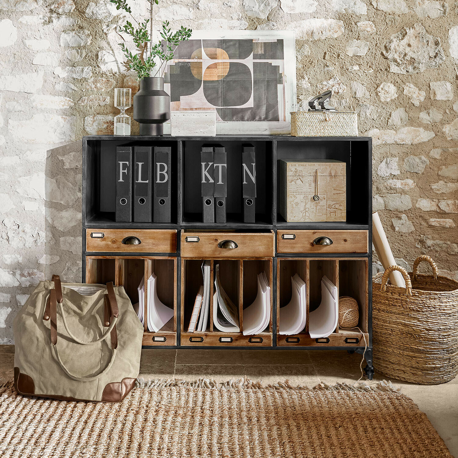 Sideboard Fenwicke Schwarzer Metall-Holz-Schrank mit Schubladen und Ordnern vor rustikaler Steinwand im Vintage-Stil