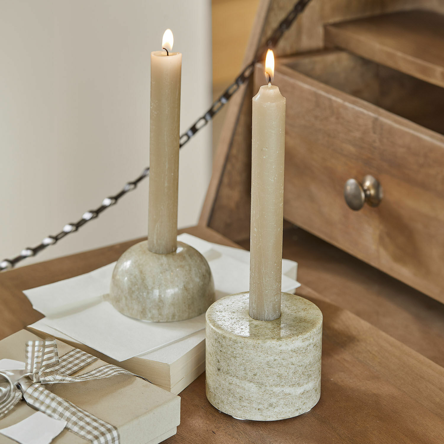 Kerzenständer 2er Set Najira Zwei beige Kerzen in Marmor-Kerzenhaltern auf Holztisch, stilvolle Wohnraumdekoration