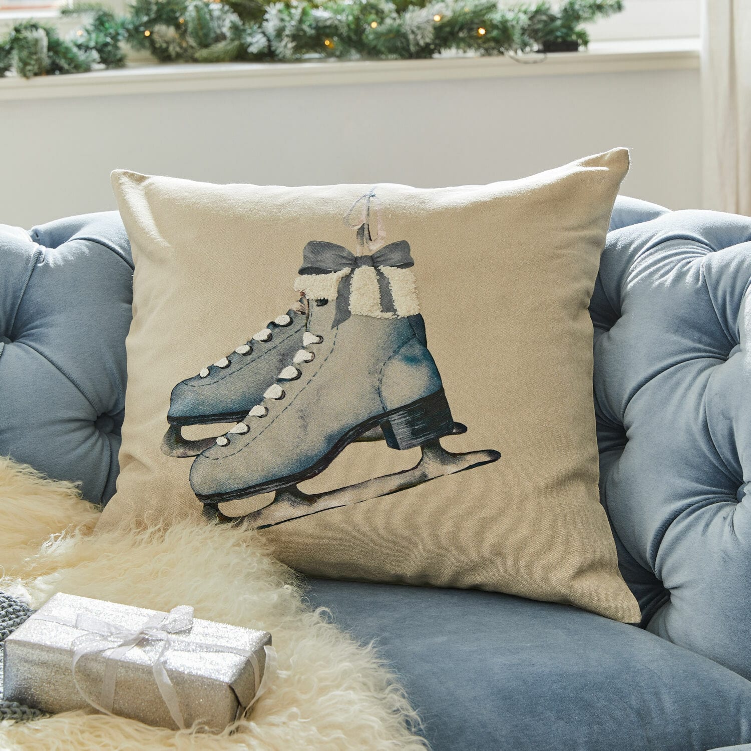 Kissenhülle Herveline Beiges Kissen mit blauem Schlittschuh-Motiv auf blauem Sofa, winterliche und festliche Dekoration