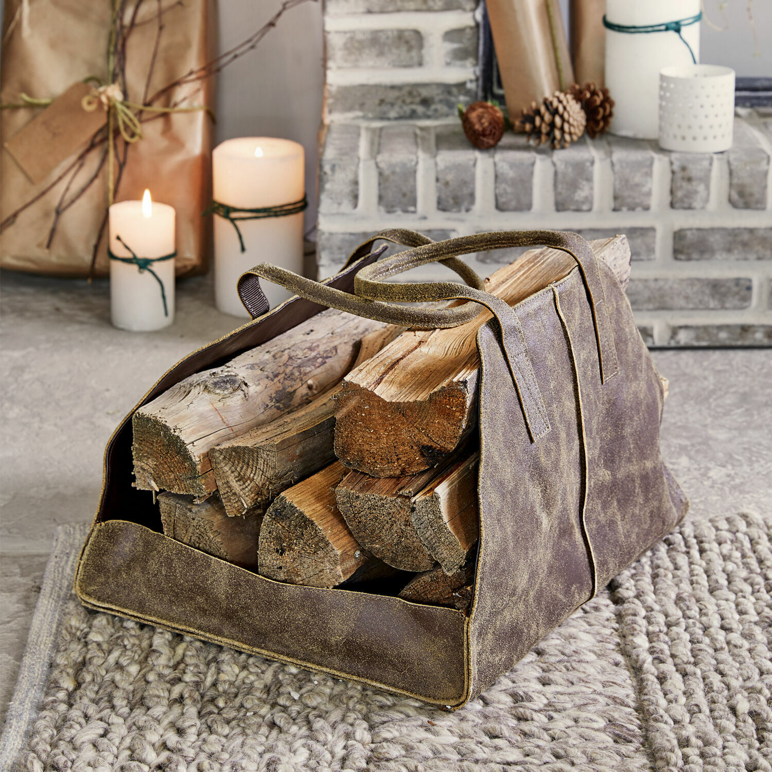 Tragetasche Bassila Braune Ledertasche für Kaminholz mit Griffen auf grauem Teppich vor dem Kamin