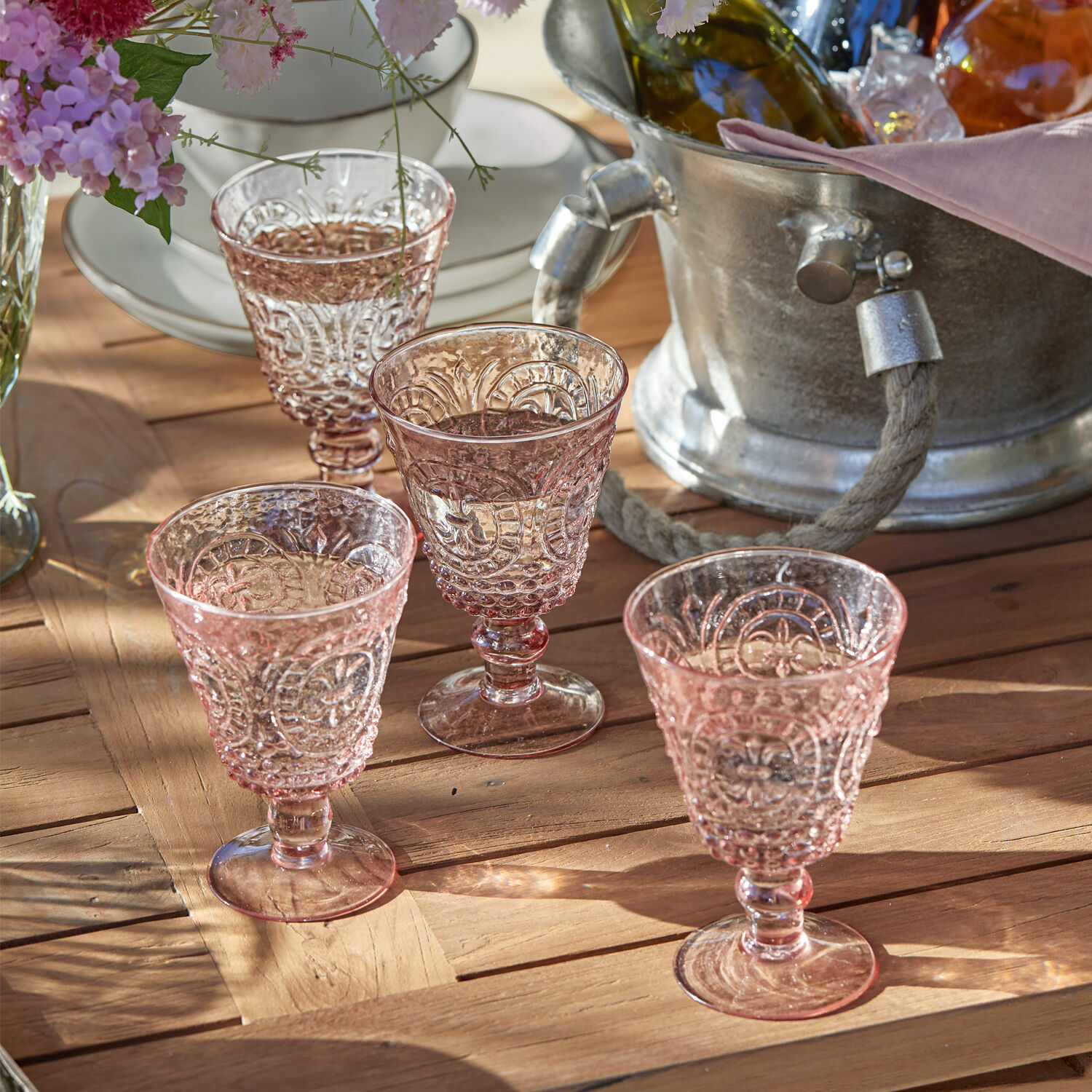 Weingläser 4er Set Sarton Vier rosa Gläser aus geprägtem Glas auf Holztisch, dekoratives Set für den Tisch