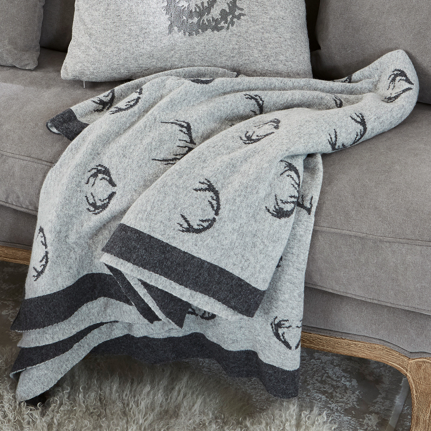 Wendedecke Lodge Graue Wolldecke mit schwarzem Hirschgeweih-Muster auf grauem Sofa, gemütliche Wohnraumdeko