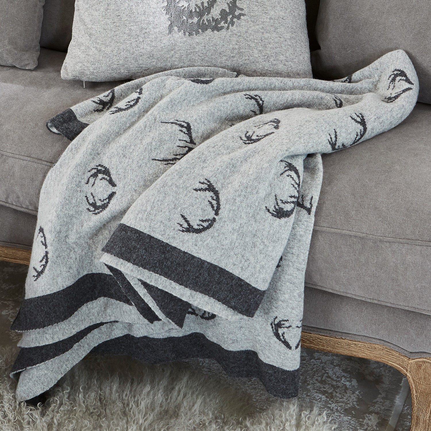 Wendedecke Lodge Graue Wolldecke mit schwarzem Hirschgeweih-Muster auf grauem Sofa, gemütliche Wohnraumdeko