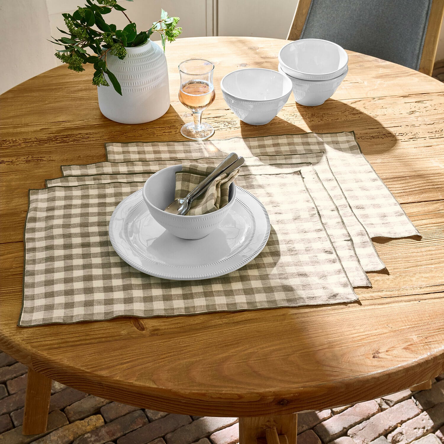 Platzset 4er Set Marrowby Weiße Keramikschalen und Teller auf Holztisch mit beige-weiß karierten Leinenplatzsets